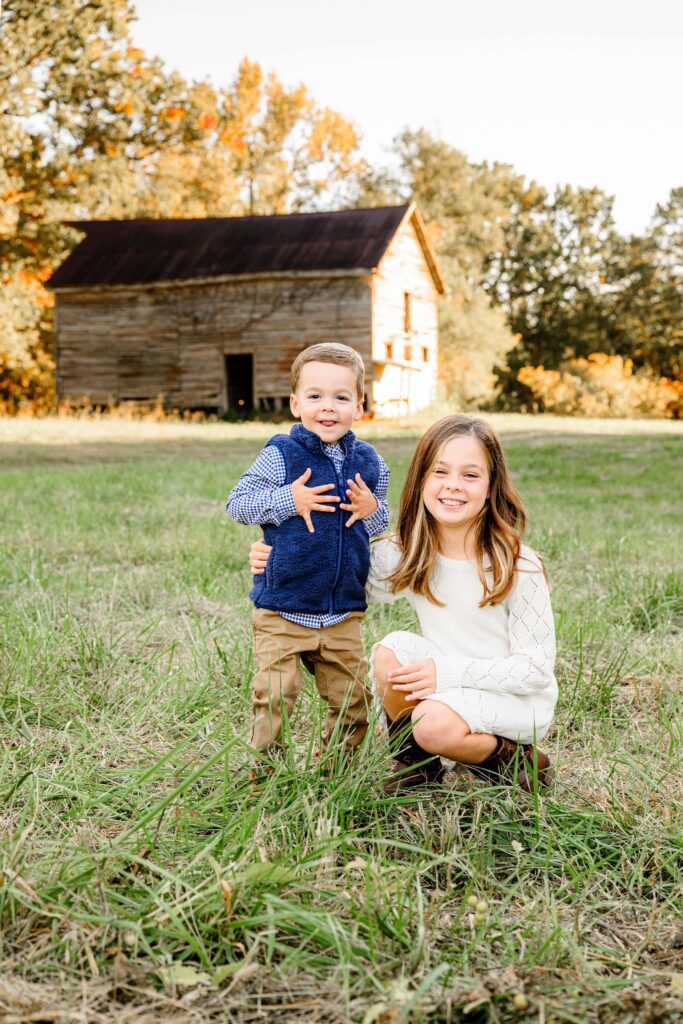 Sibling kids smiling and posed together during a fall family mini session.