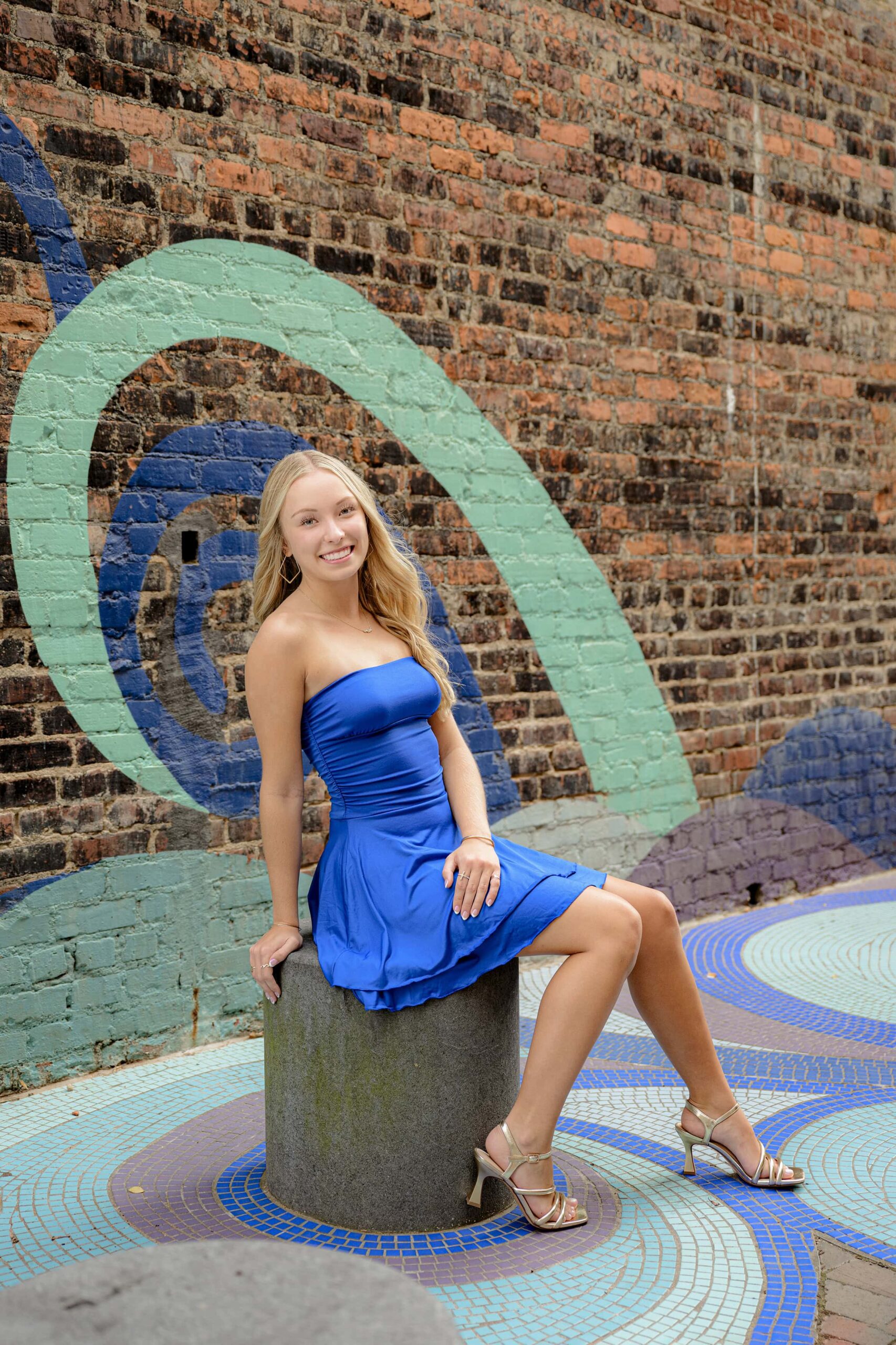 blonde grad sits on a pedestal in a urban rock hill sc location