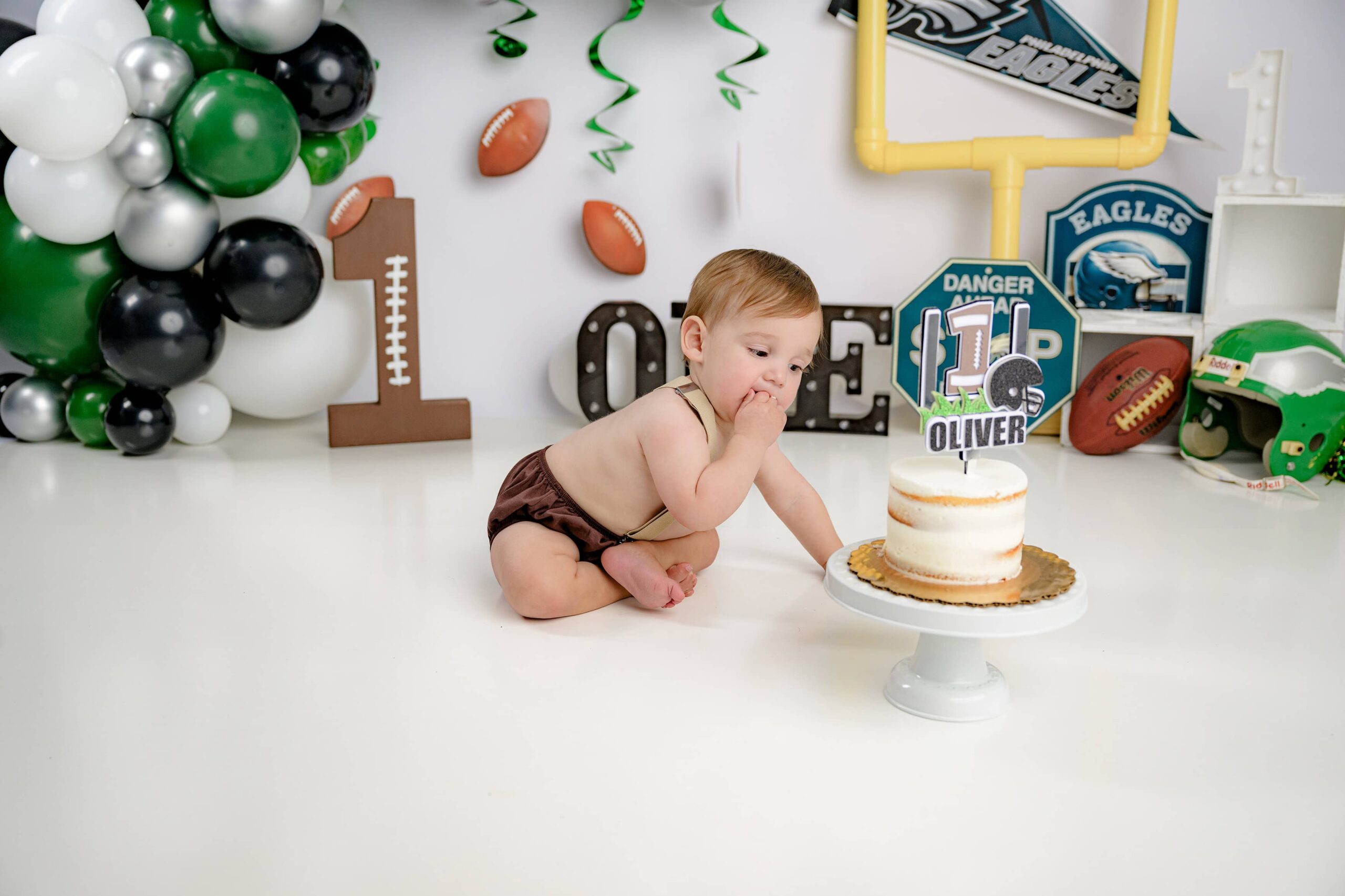 taking his first big bite of his cake during his cake smash celebrating turning one