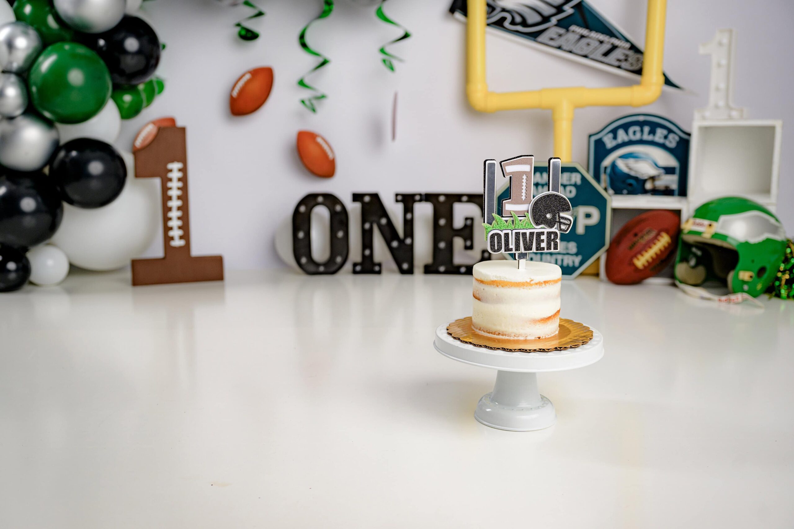 the naked cake is the highlight of this photo in a eagles themed cake smash set up
