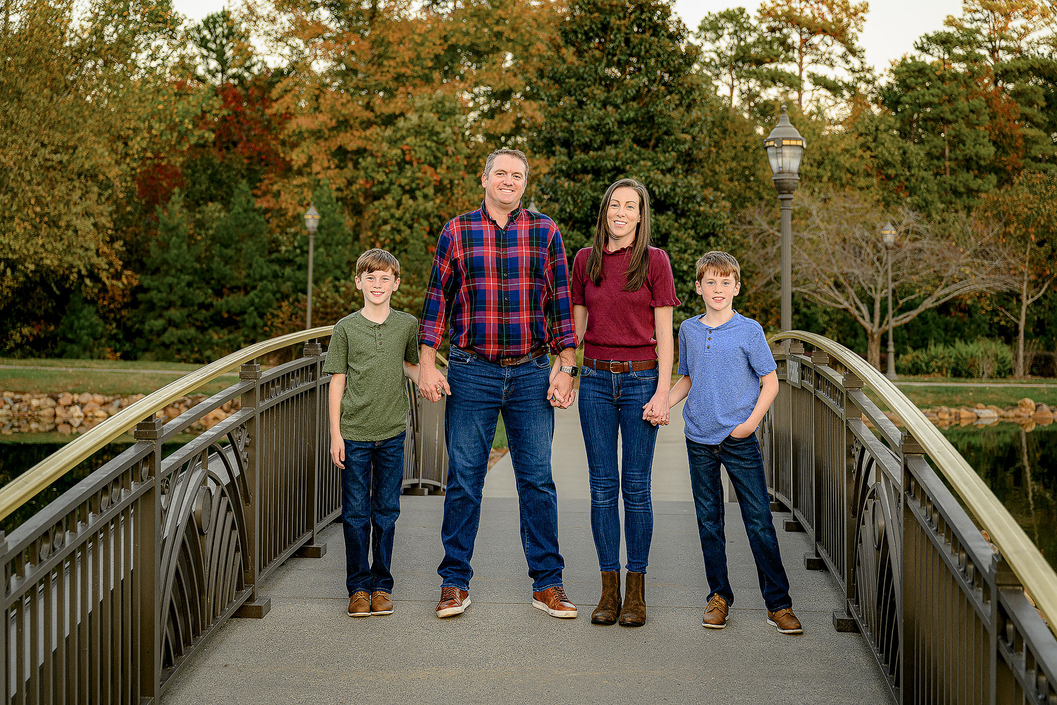 Fall Family photo session with a family of 3 dressed in warm fall tones of burgundy, navy, and green