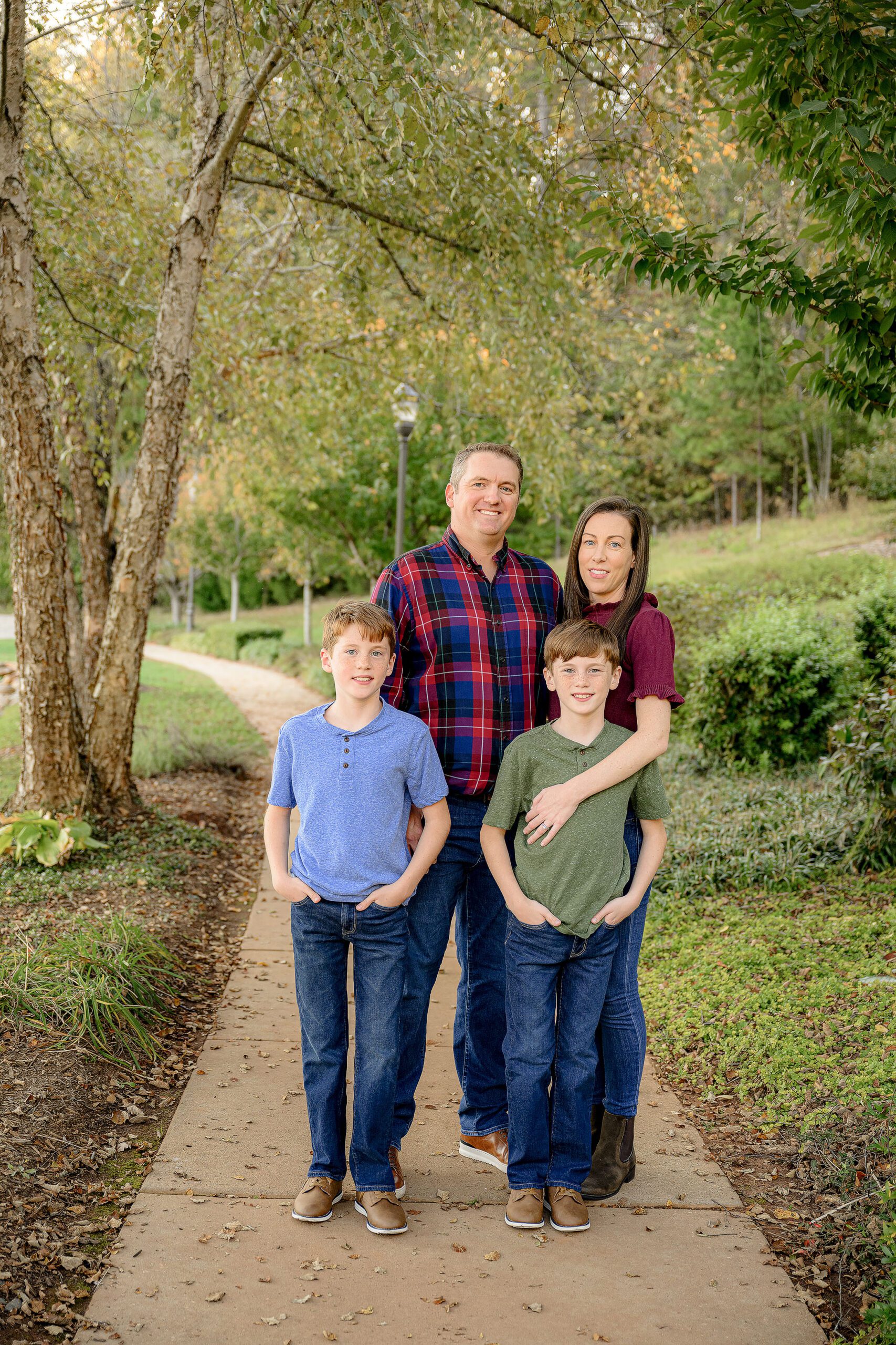 family of four standing together dressed in warm fall tones