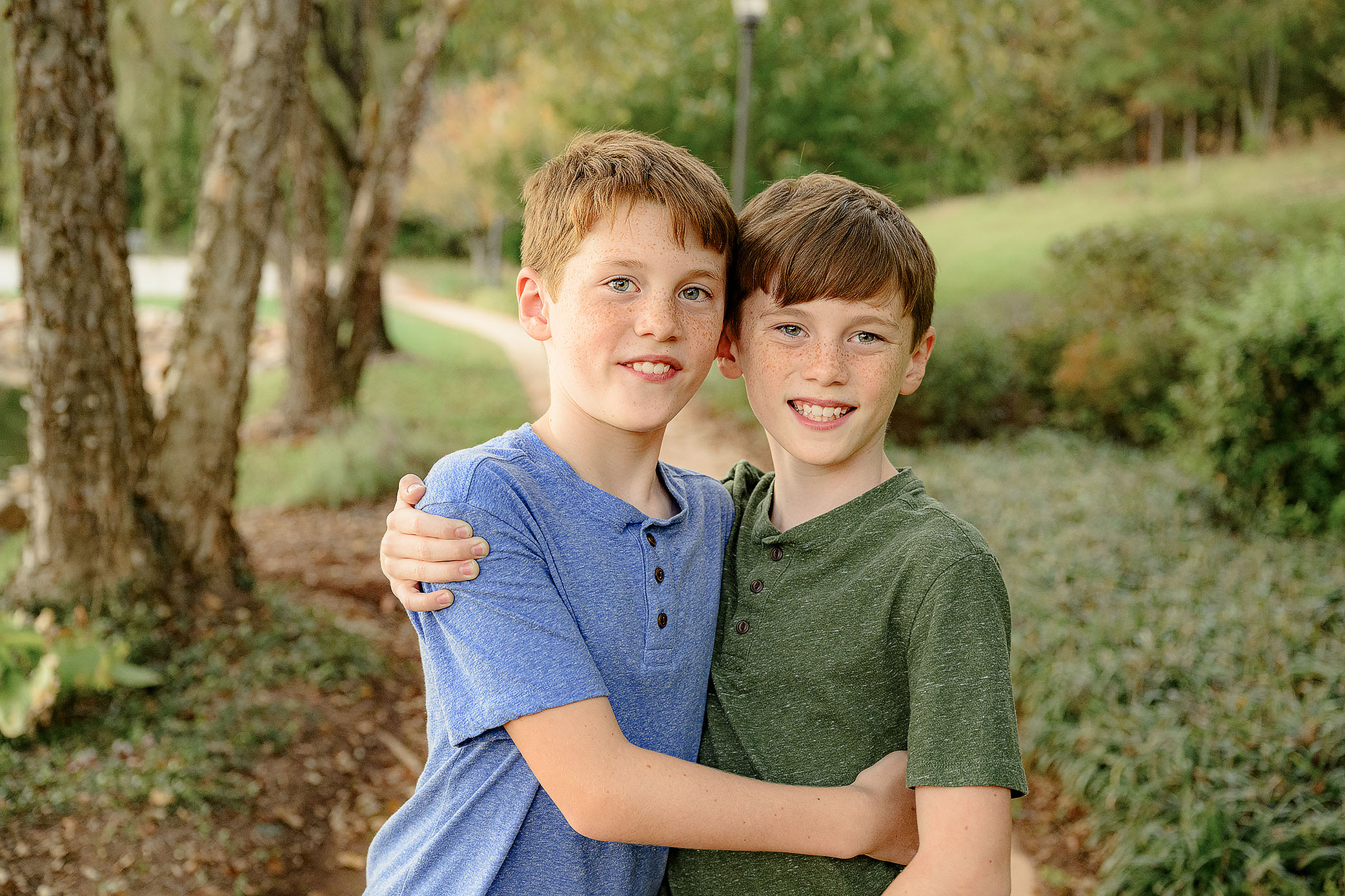 twin brothers embrace each wearing a blue or green shirt