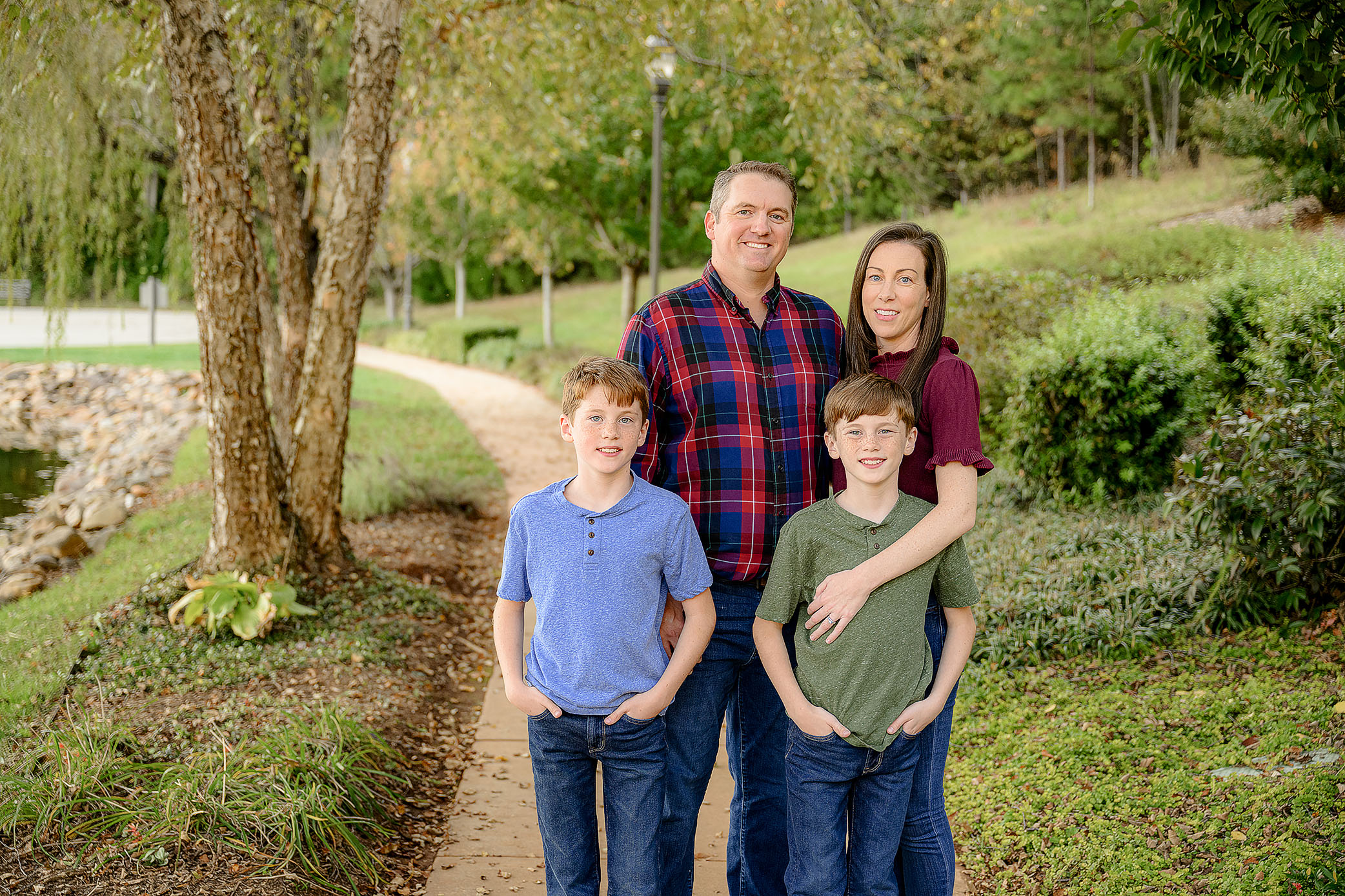 cropped photo of family of four standing together dressed in warm fall tones
