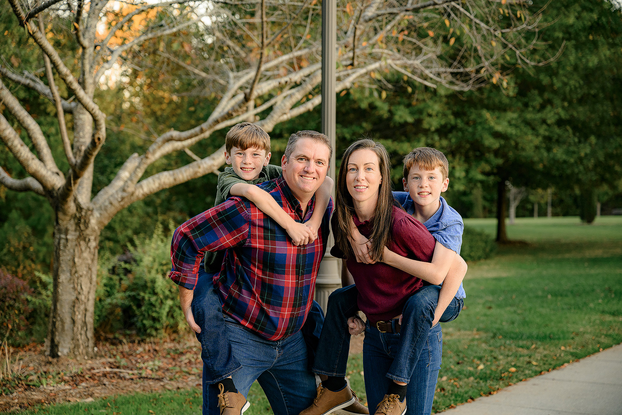 9 year old boys riding piggy back on their parents