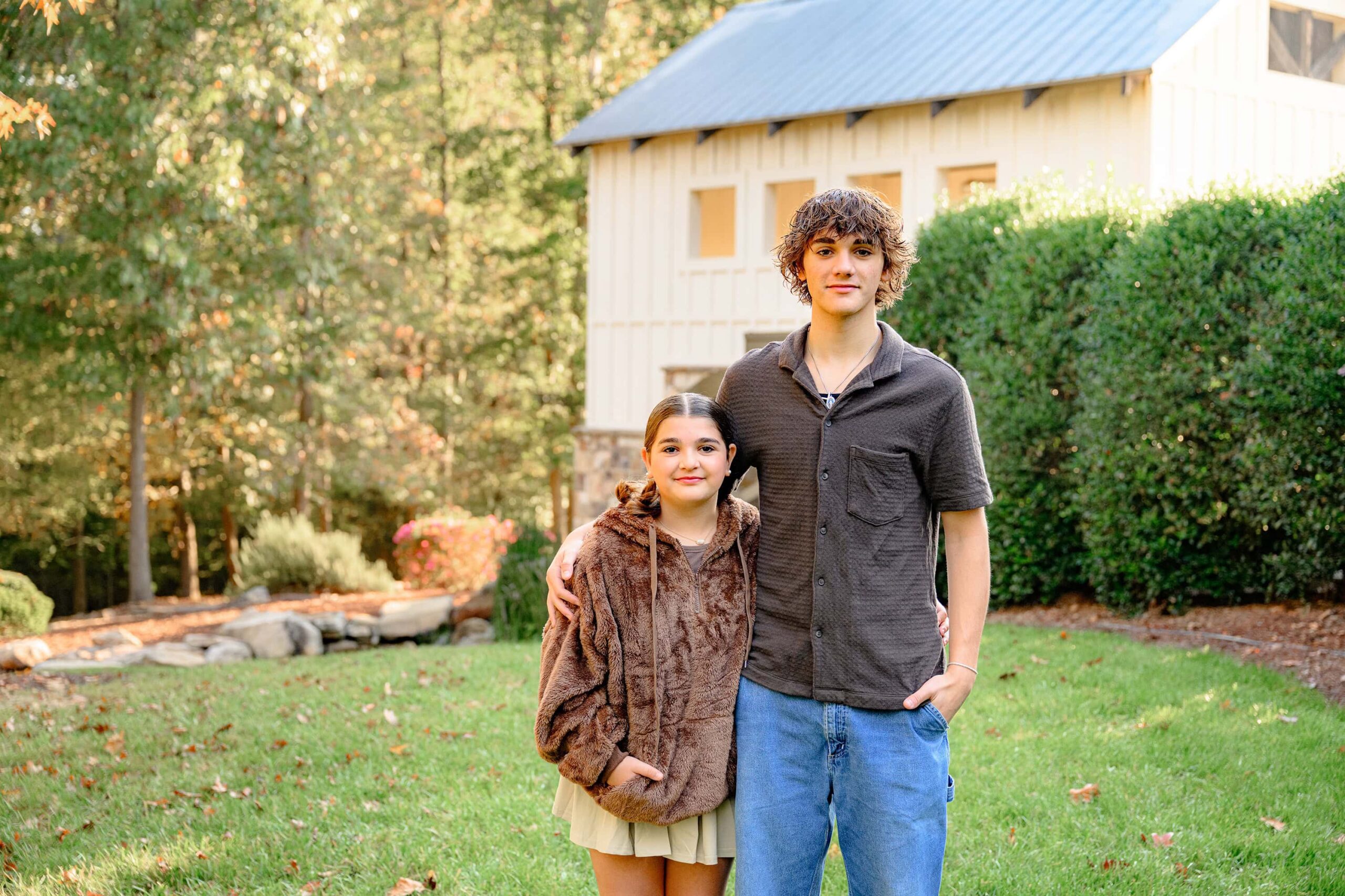 bother and sister grad images of younger sister and brother hugging wearing shades of brown during the millbridge senior session