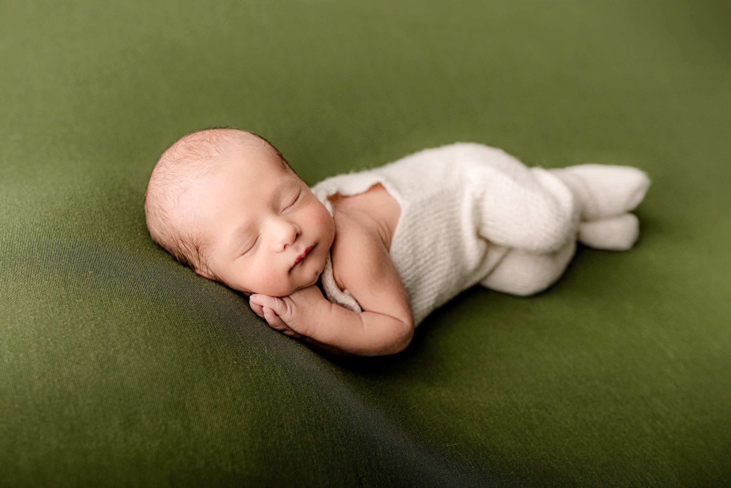 laying gently on his side this newborn baby boy is posed perfectly for his family newborn portraits in a waxhaw nc studio