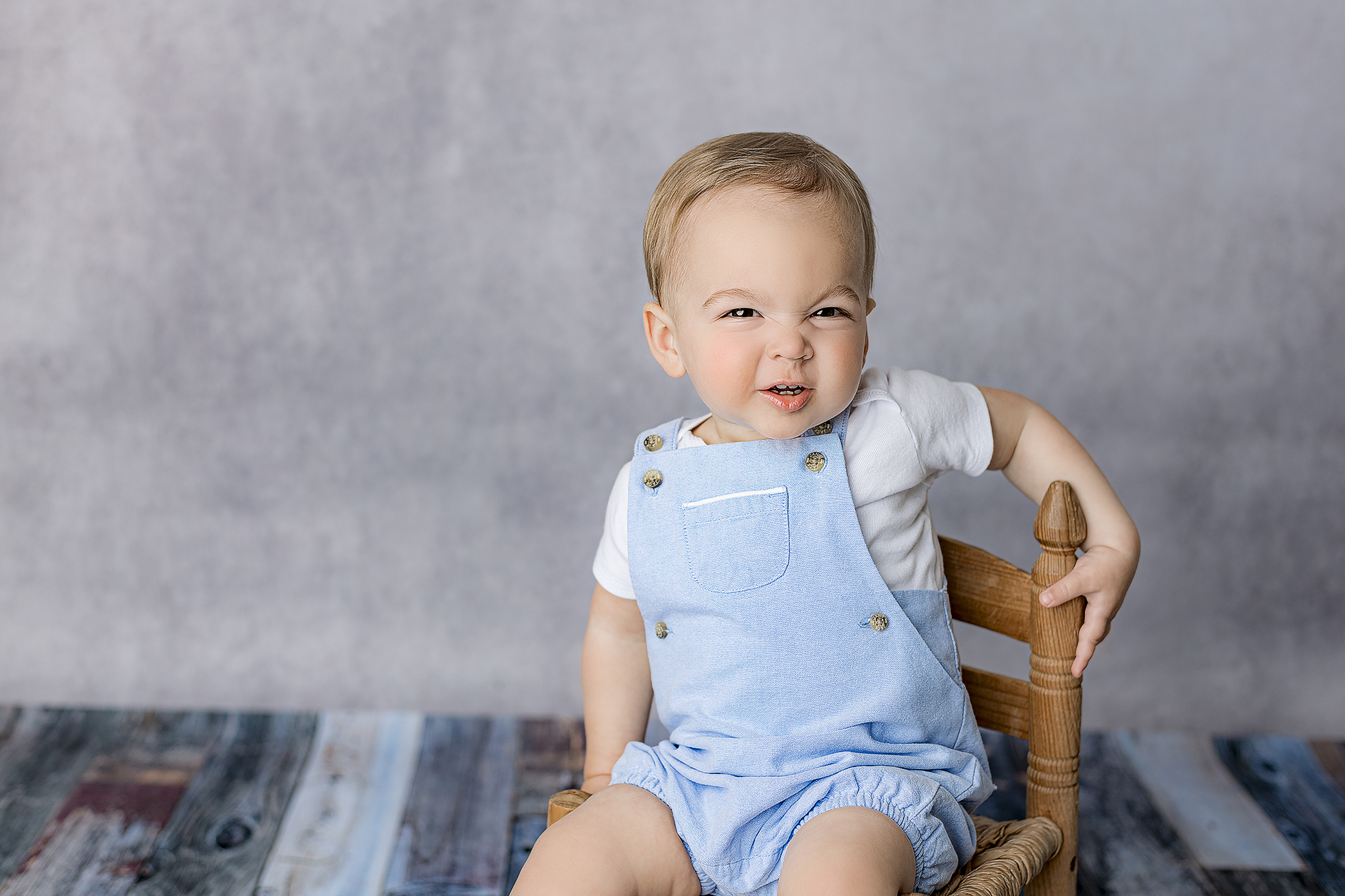 little waxhaw, nc boy crinkles up his nose while laughing during his studio one year milestone session in charlotte nc area