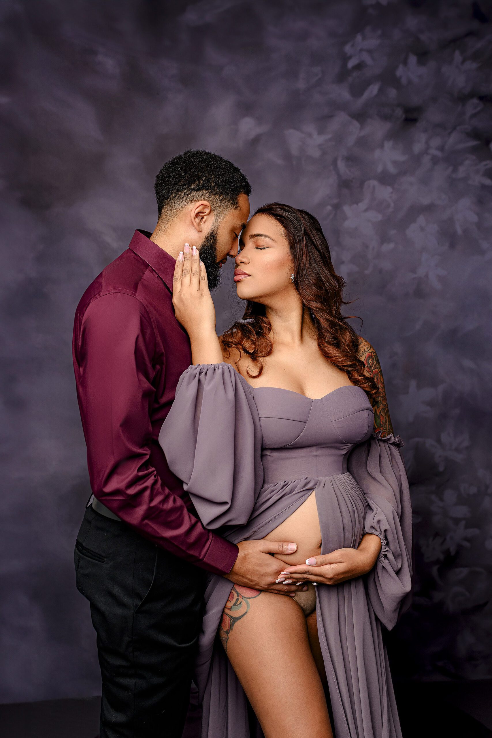 posed together nose to nose this couple is relaxing in anticipation of meeting their new baby boy and showing all the excitement of becoming parents during their charlotte nc studio session