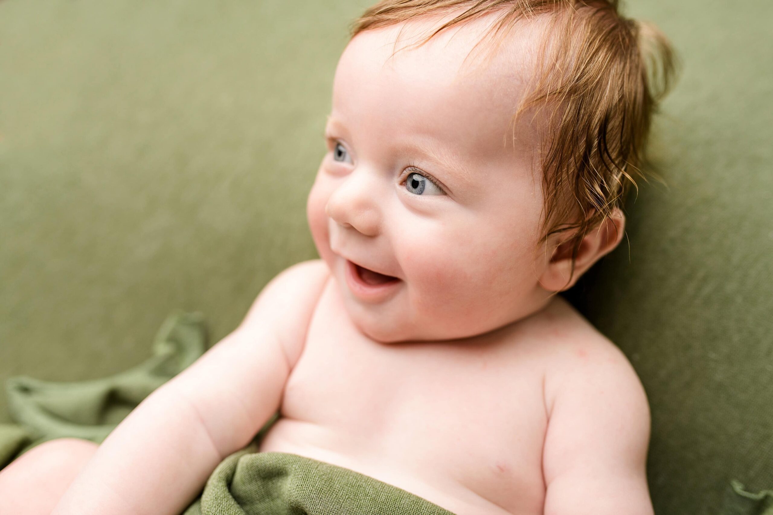 Close up image of a little 4 month old redheaded boy during his milestone photos