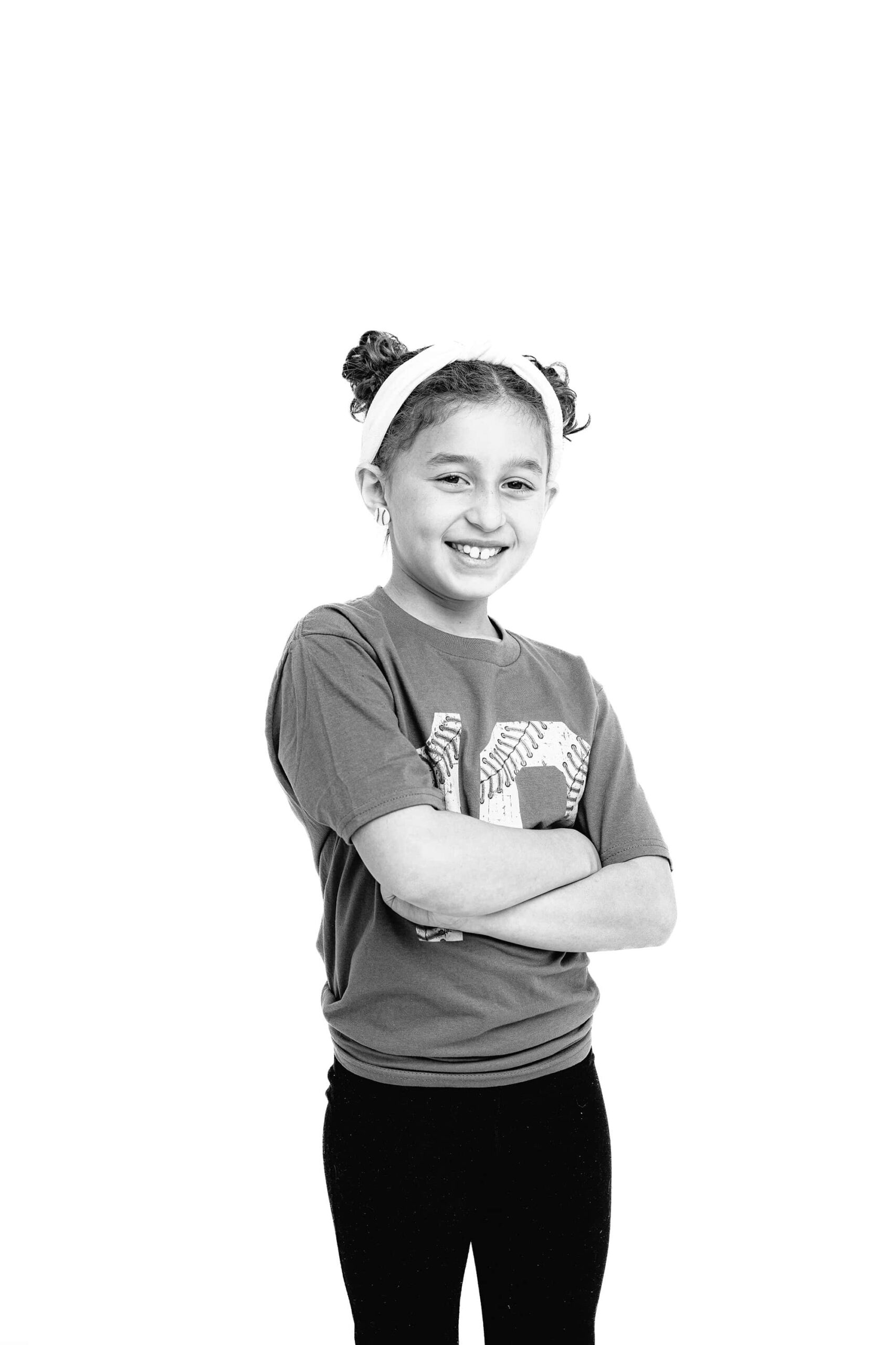 black and white image of girl standing with her arms crossed