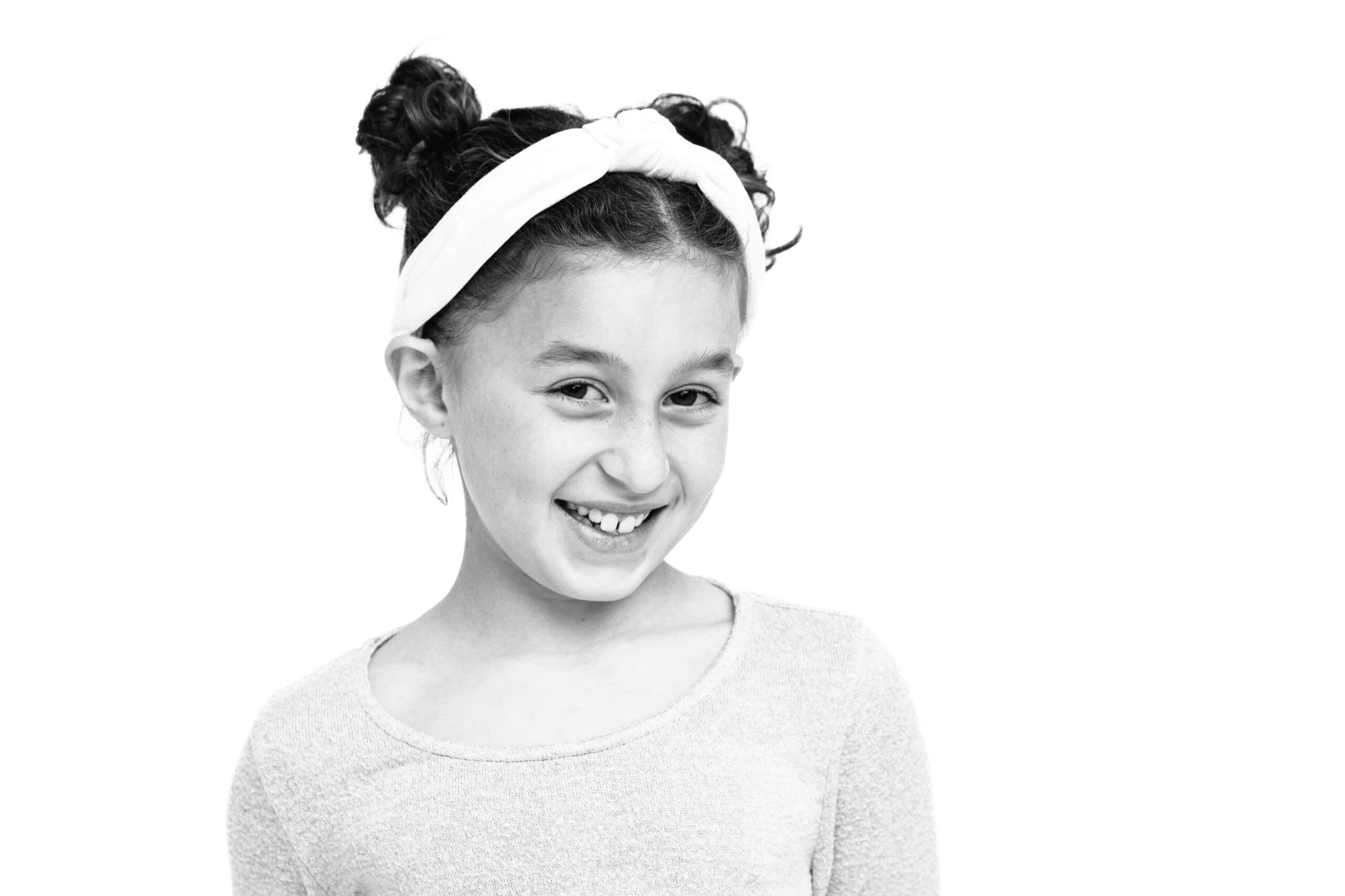 black and white personality portrait of a girl with her hair in double buns and wearing a headband