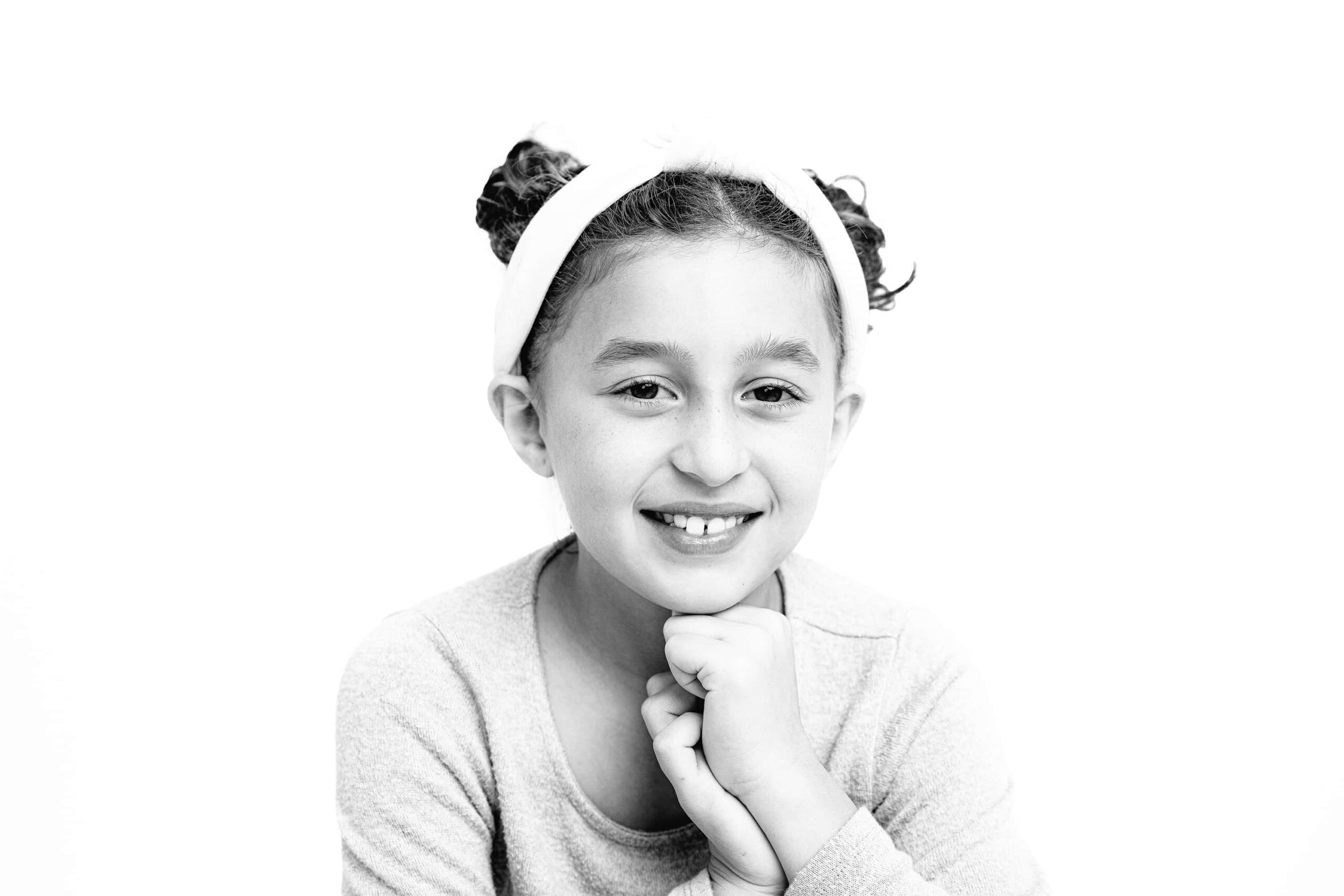 black and white image of girl with hands up by her face
