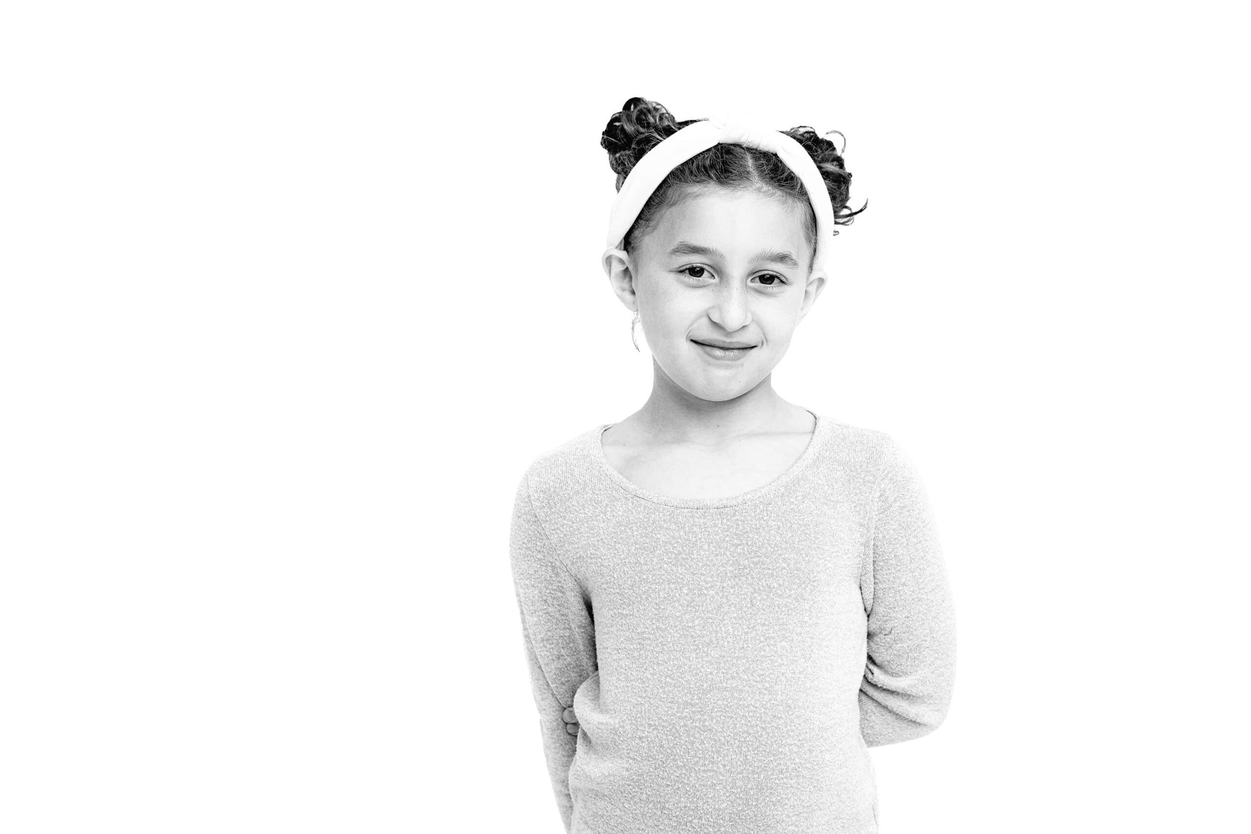black and white image of little girl with one arm behind her back