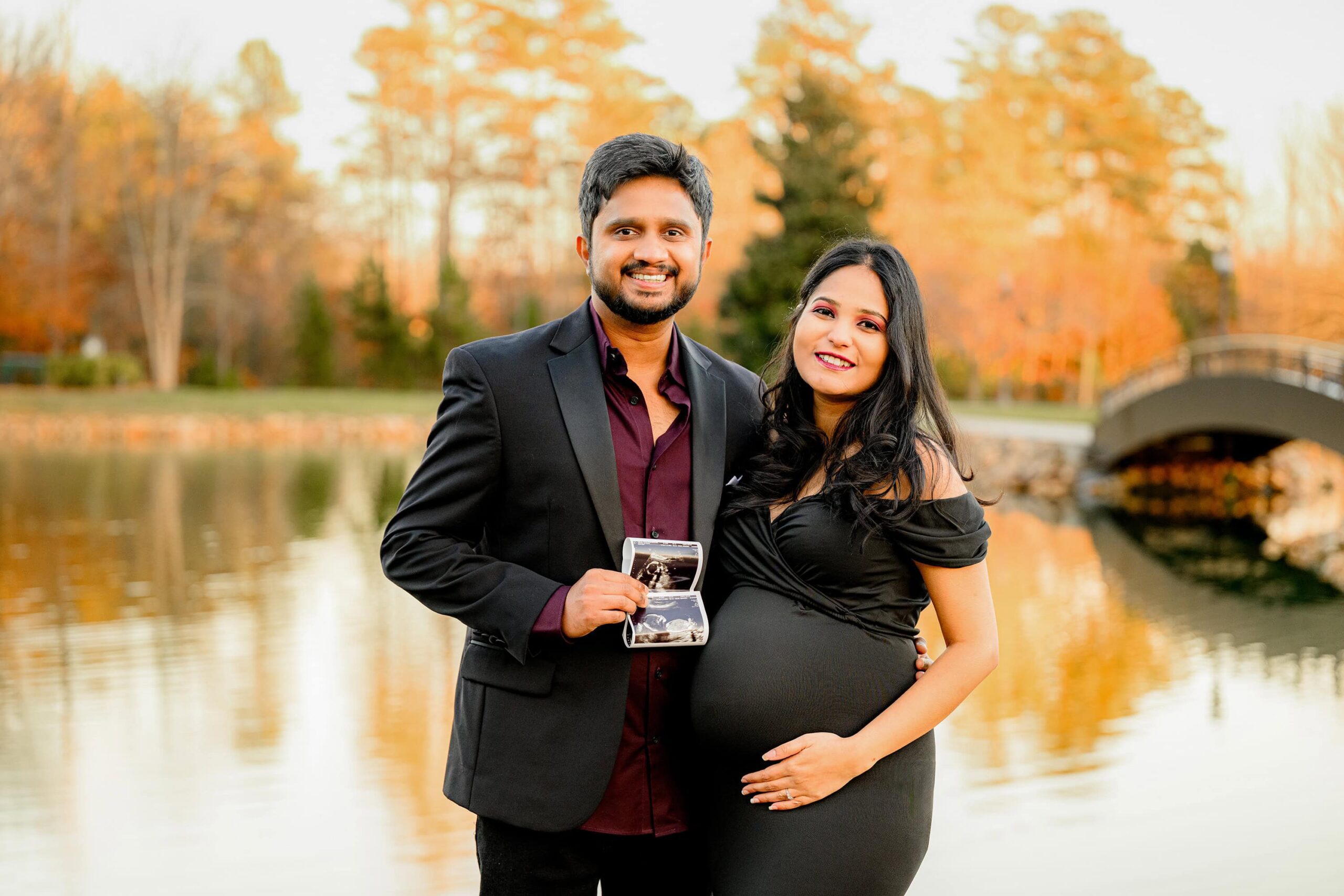 couple showing off their ultrasound photo in their maternity photoshoot