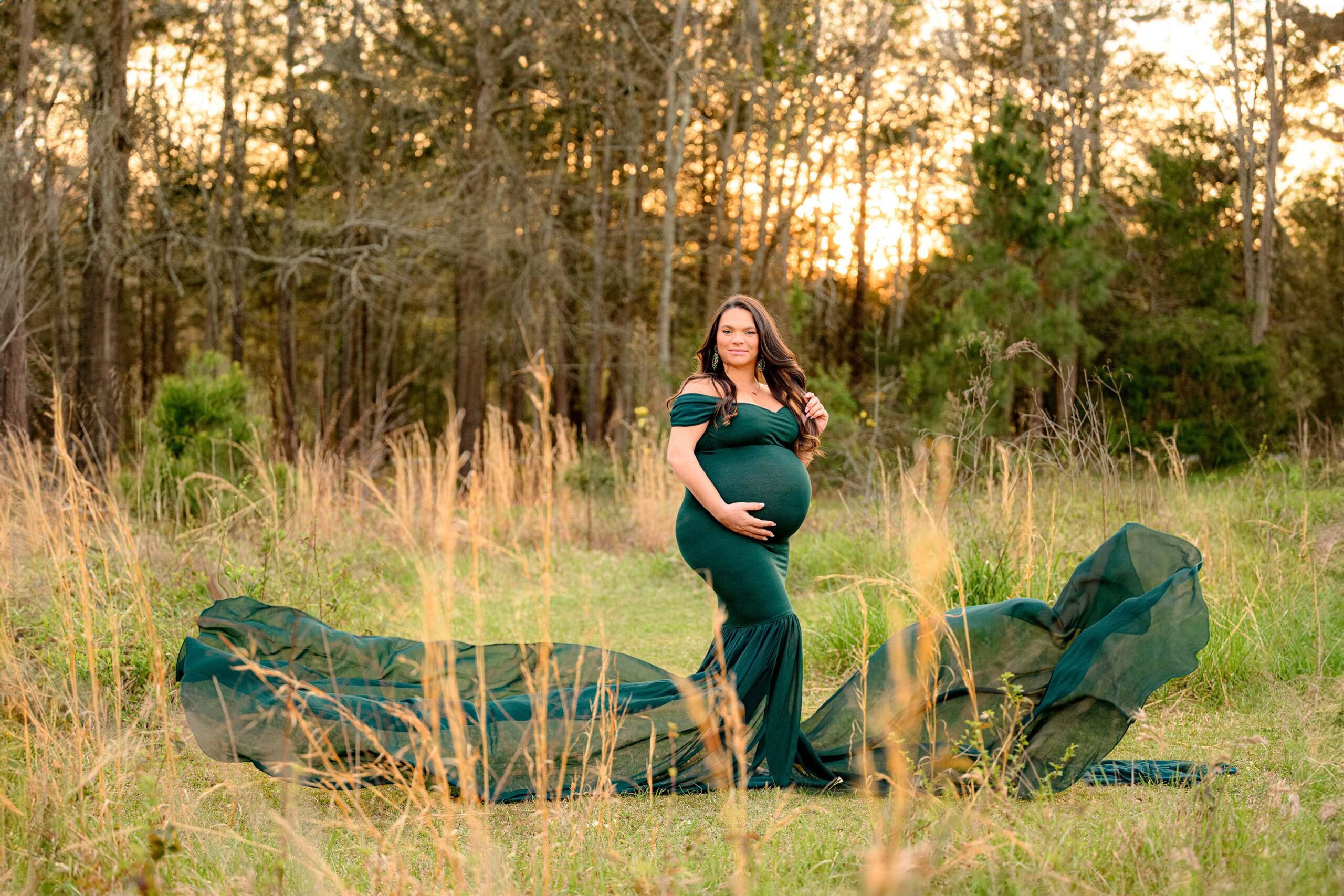 expectant charlotte mom's dramatic train is the focus of this maternity session as one hand is in her hair and the other is on her belly