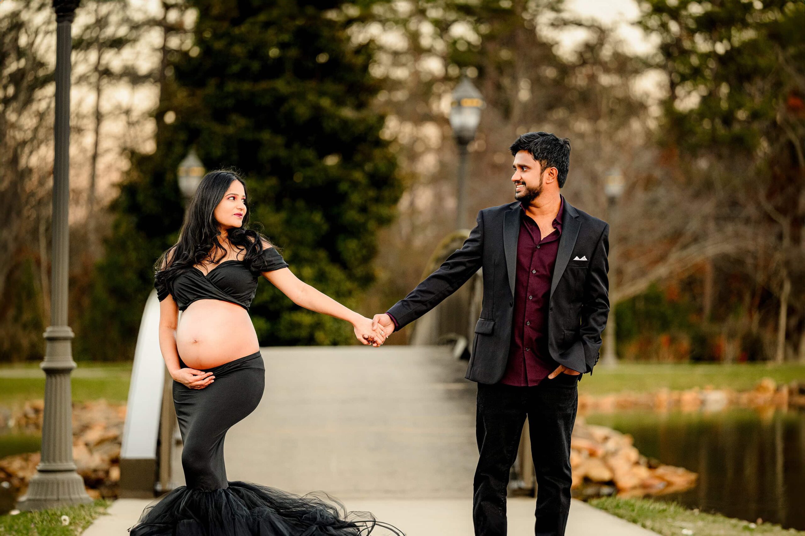 expectant couple holds hands posing together while dressed in full glam at a local south carolina park