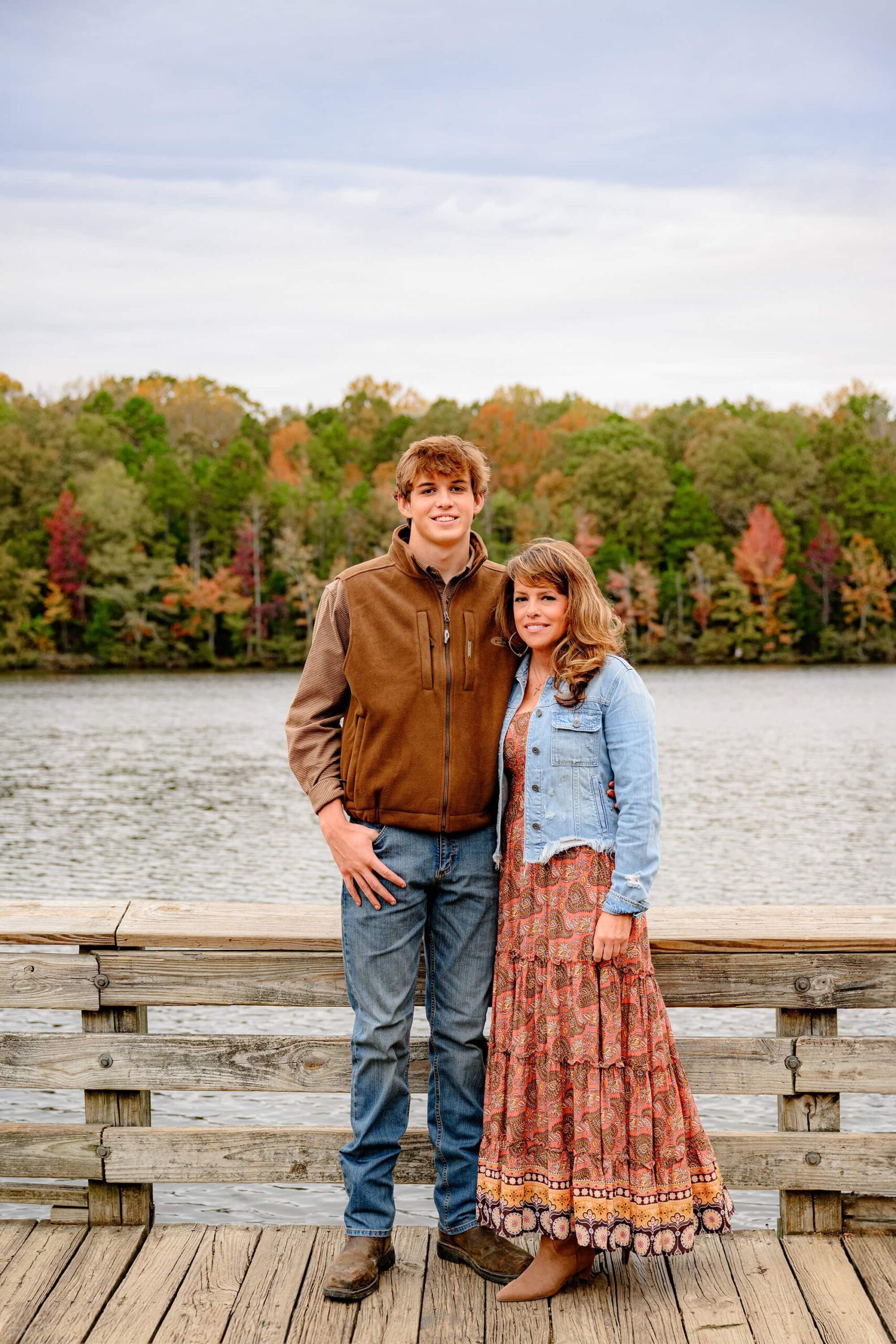 photo of a mother wearing a jean jacket standing next to her son for a mother son photo for his senior session in lancaster, sc
