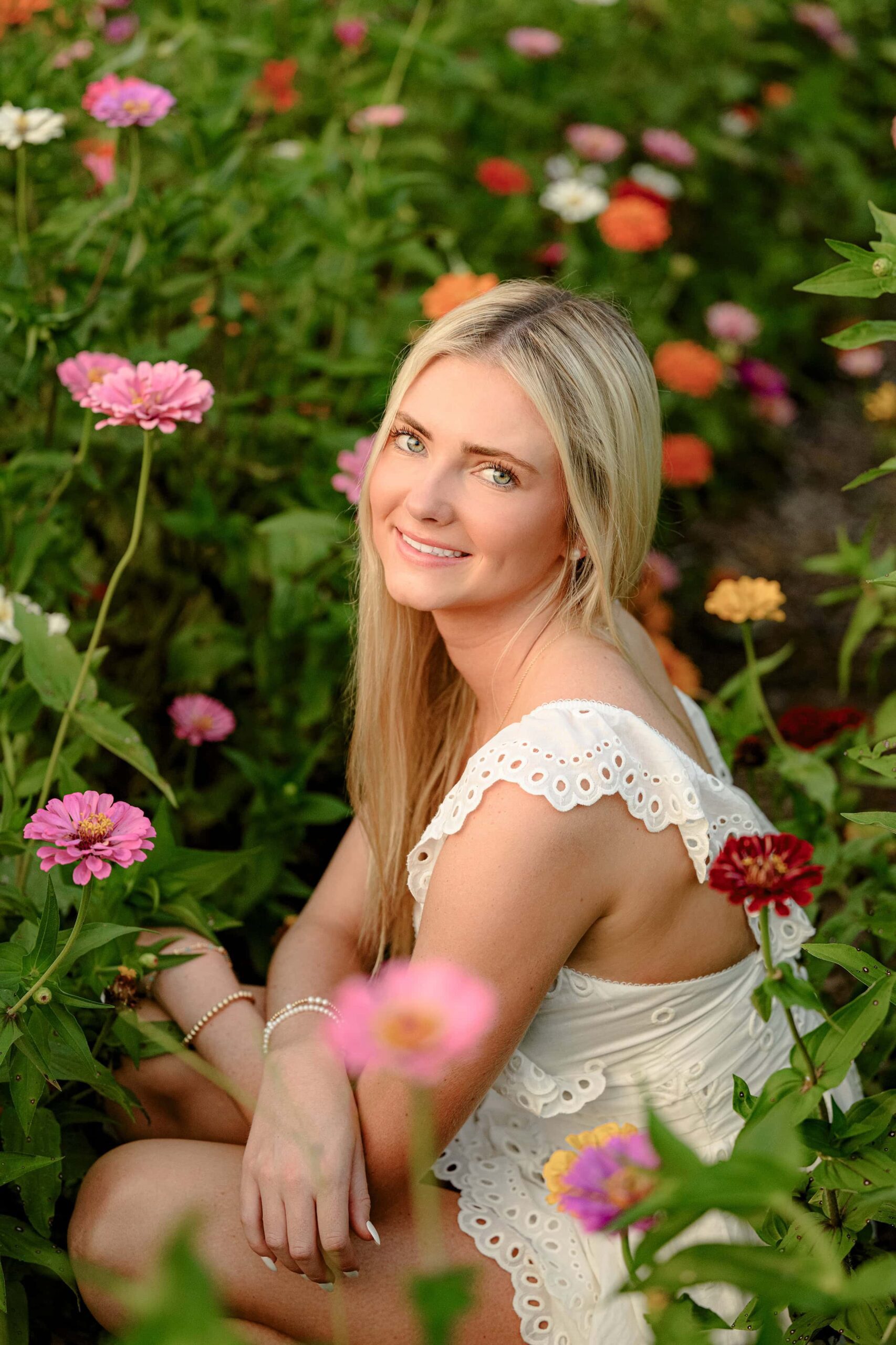 senior girl sits amongst summer blooms in indianland sc