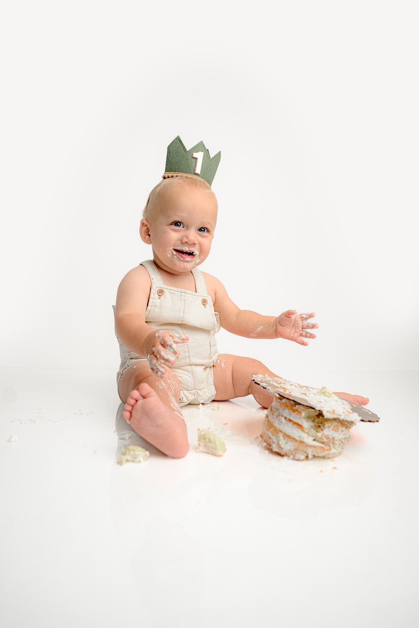little charlotte boy smiles as he plays in his smash cake for his birthday