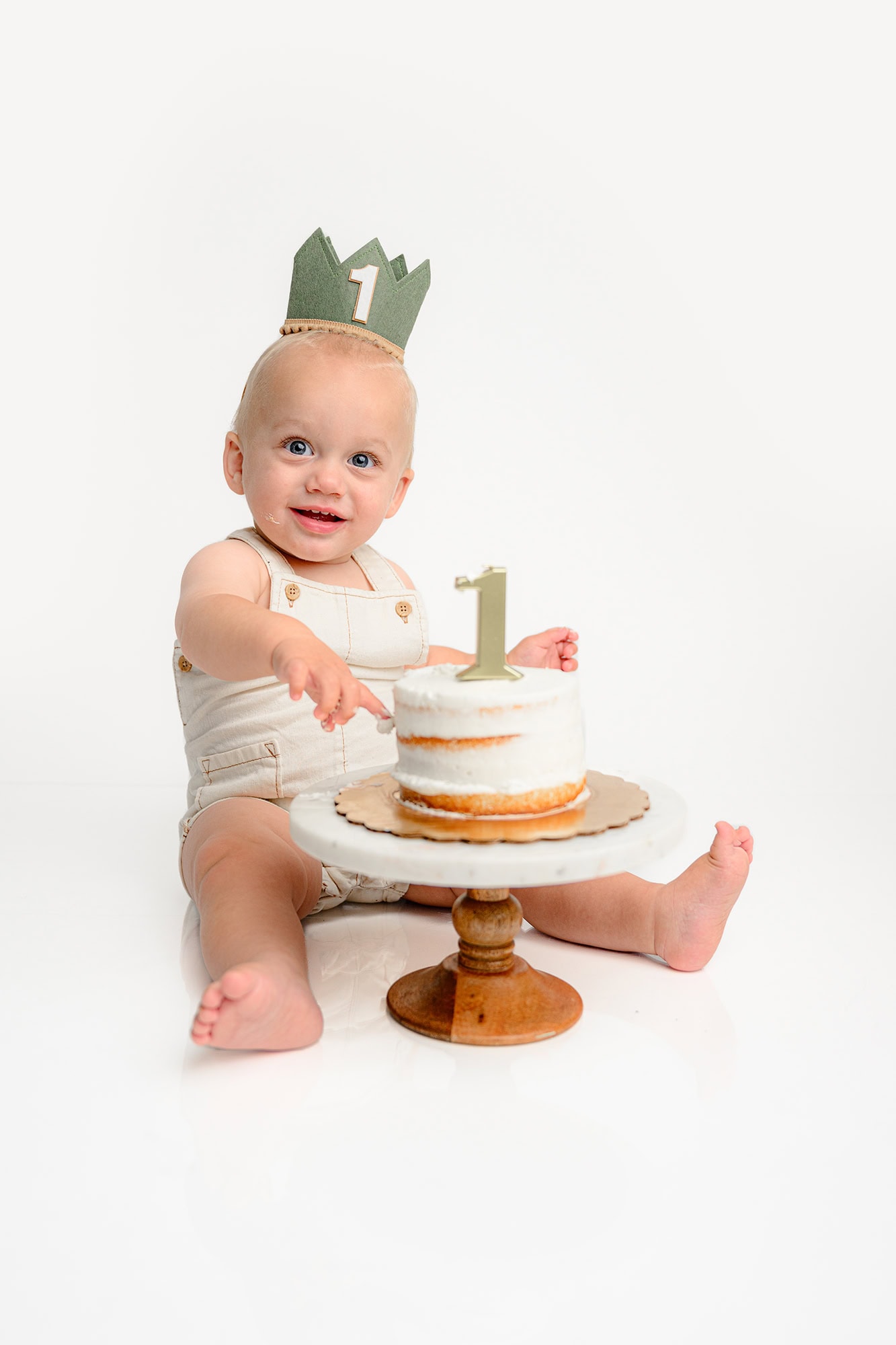 little boy starts digging into his cake for his birthday photos