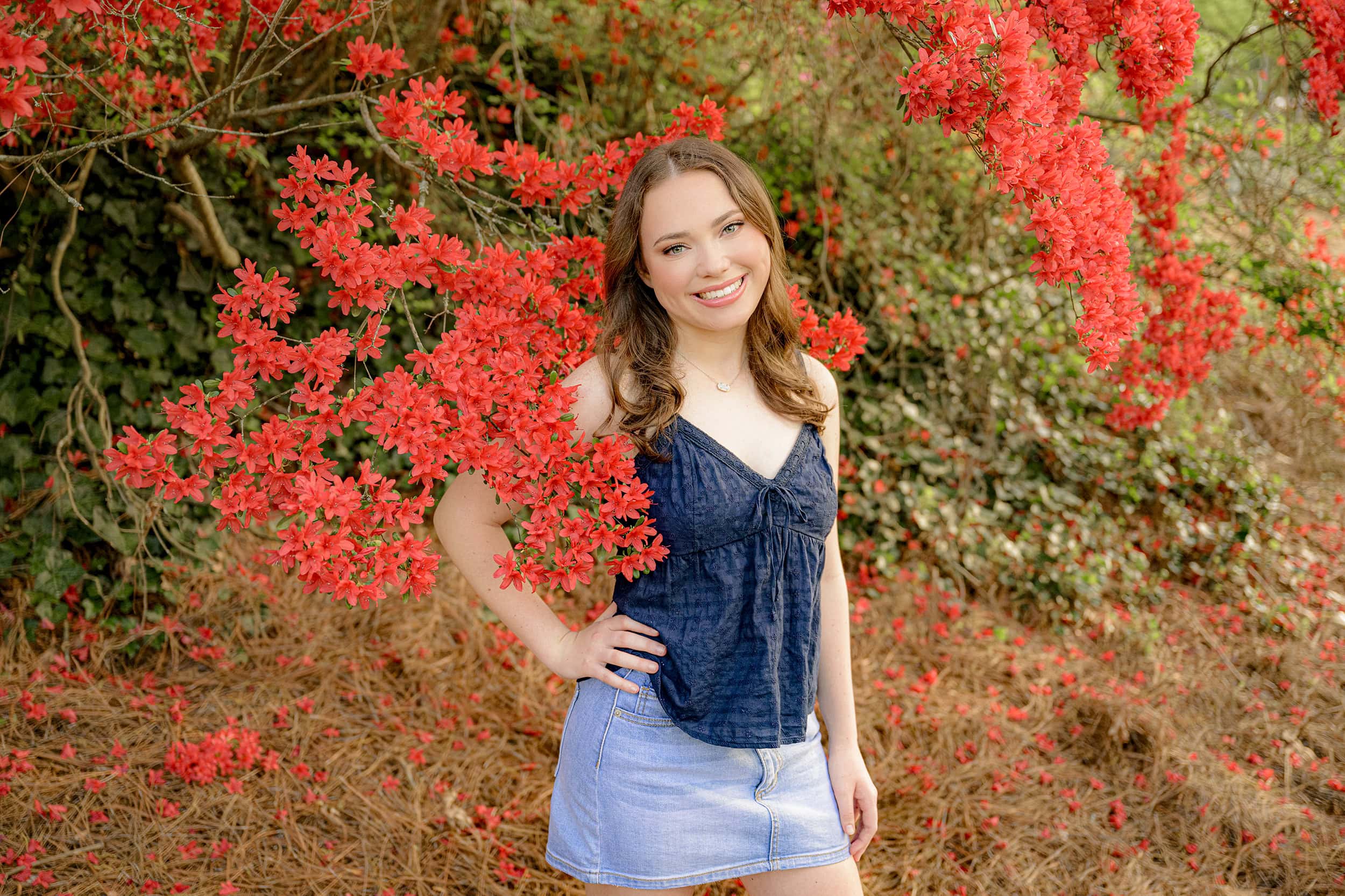 cuthbertson high senior wearing blue top and jean skirt amongst florals