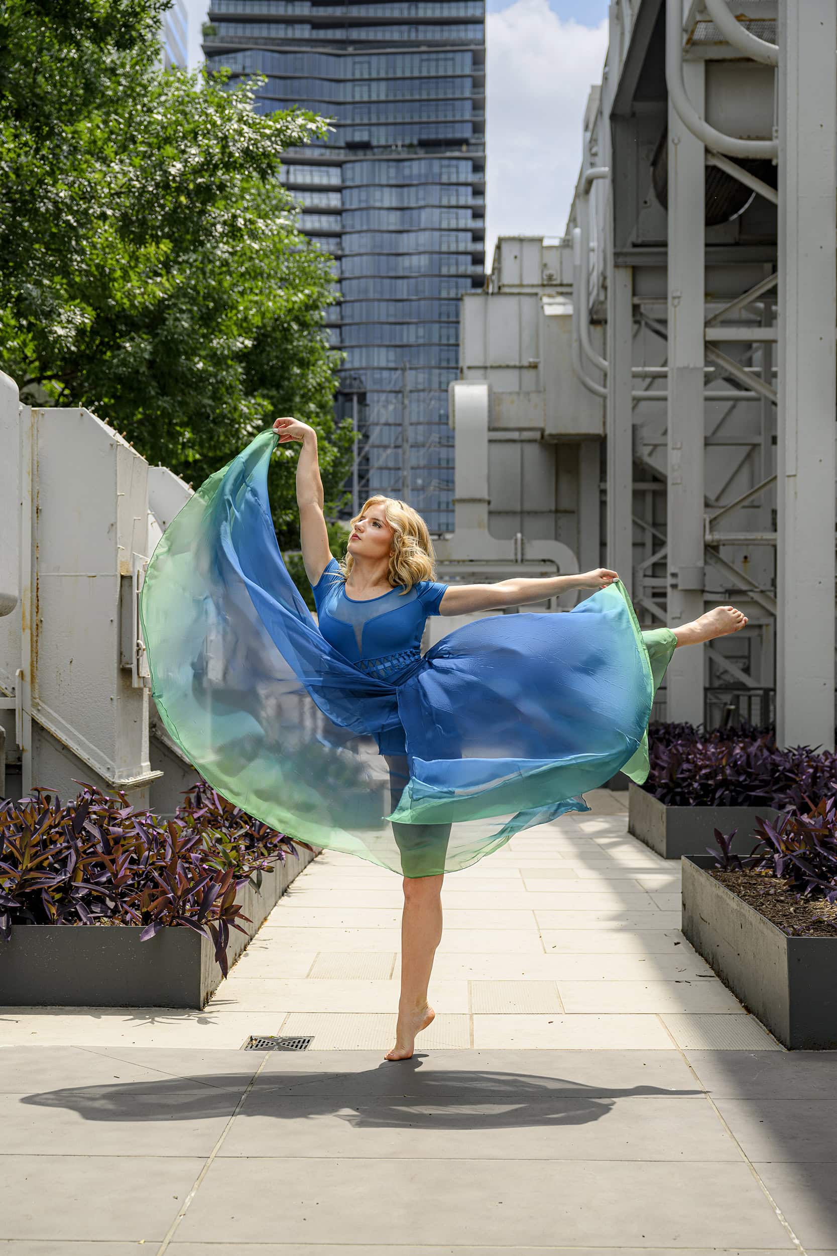 dancer poses in a dramatic city pose with skirt flying around her