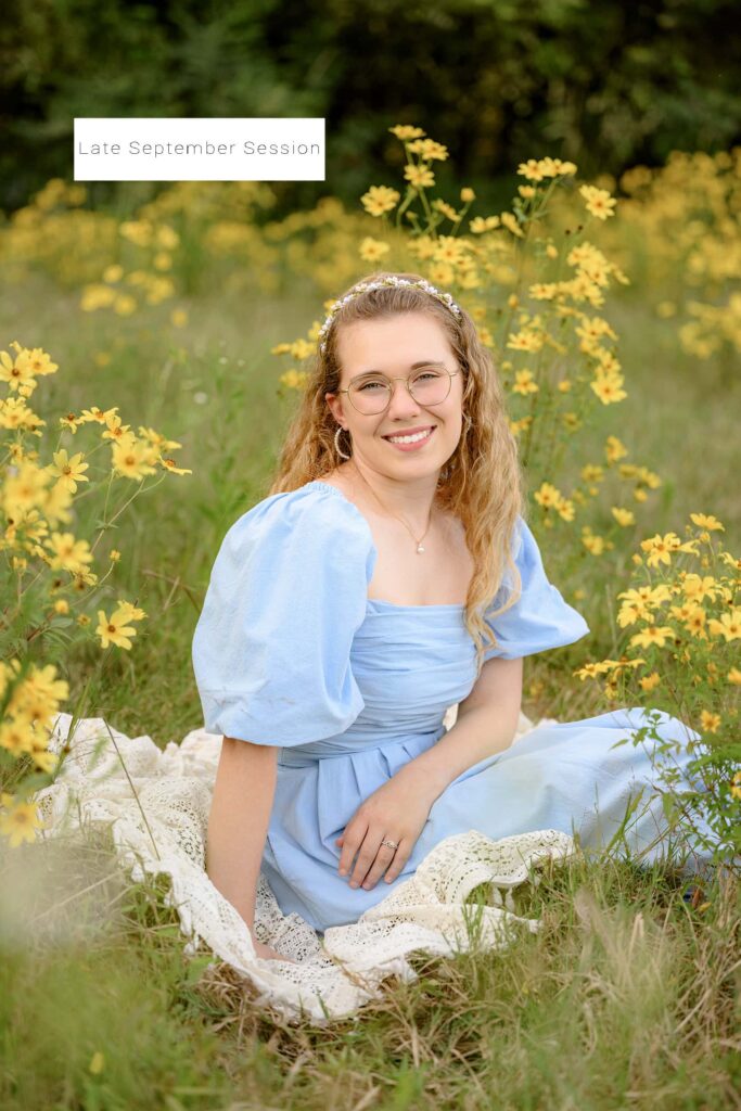 blonde senior sits in fall flower field in late september wearing a jean dress