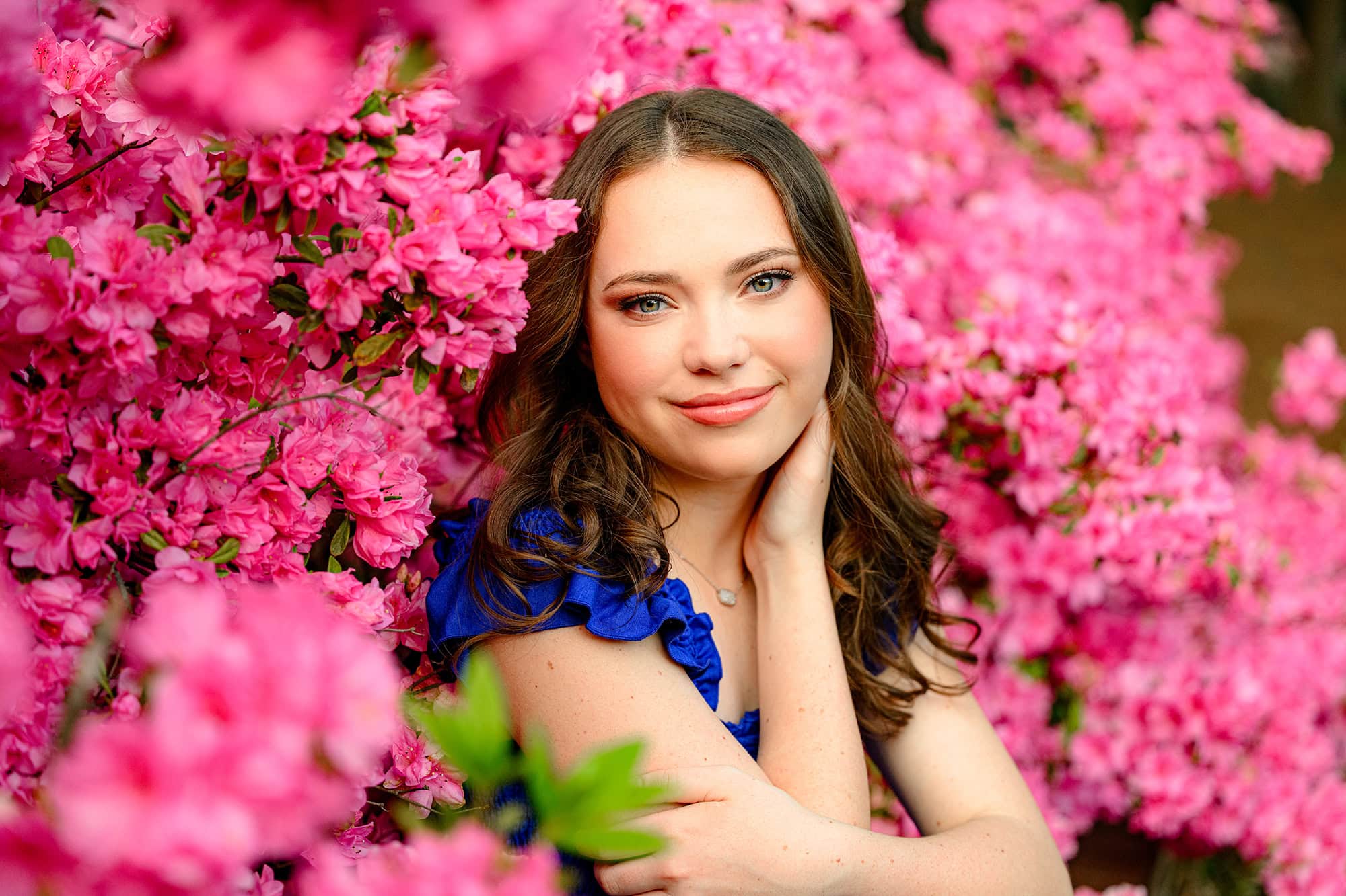 pink blooms surround this charlotte graduate wearing a blue dress
in the spring