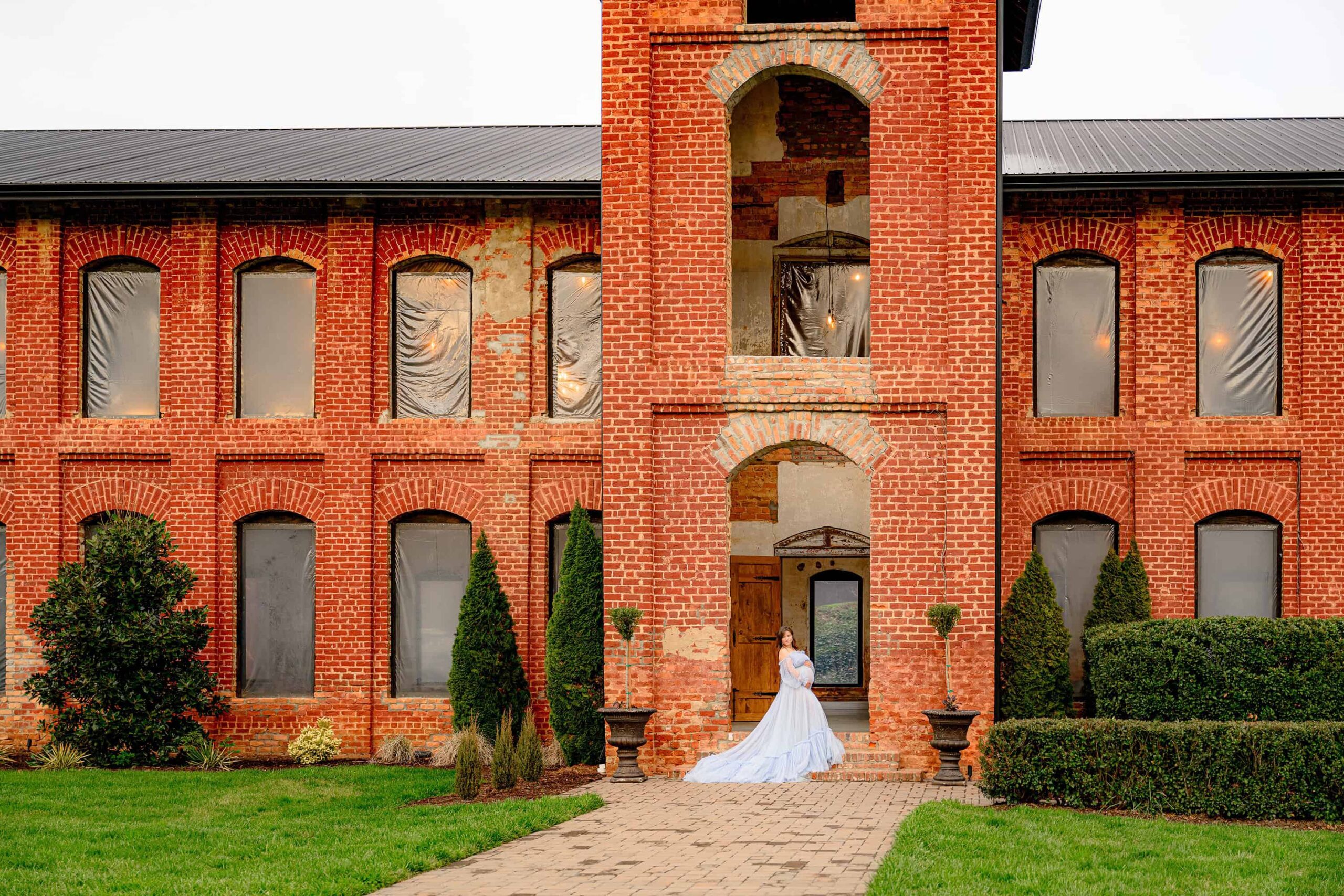 the grand back entrance of the providence cotton mill is the backdrop for this portrait of an expectant mother dressed in blue