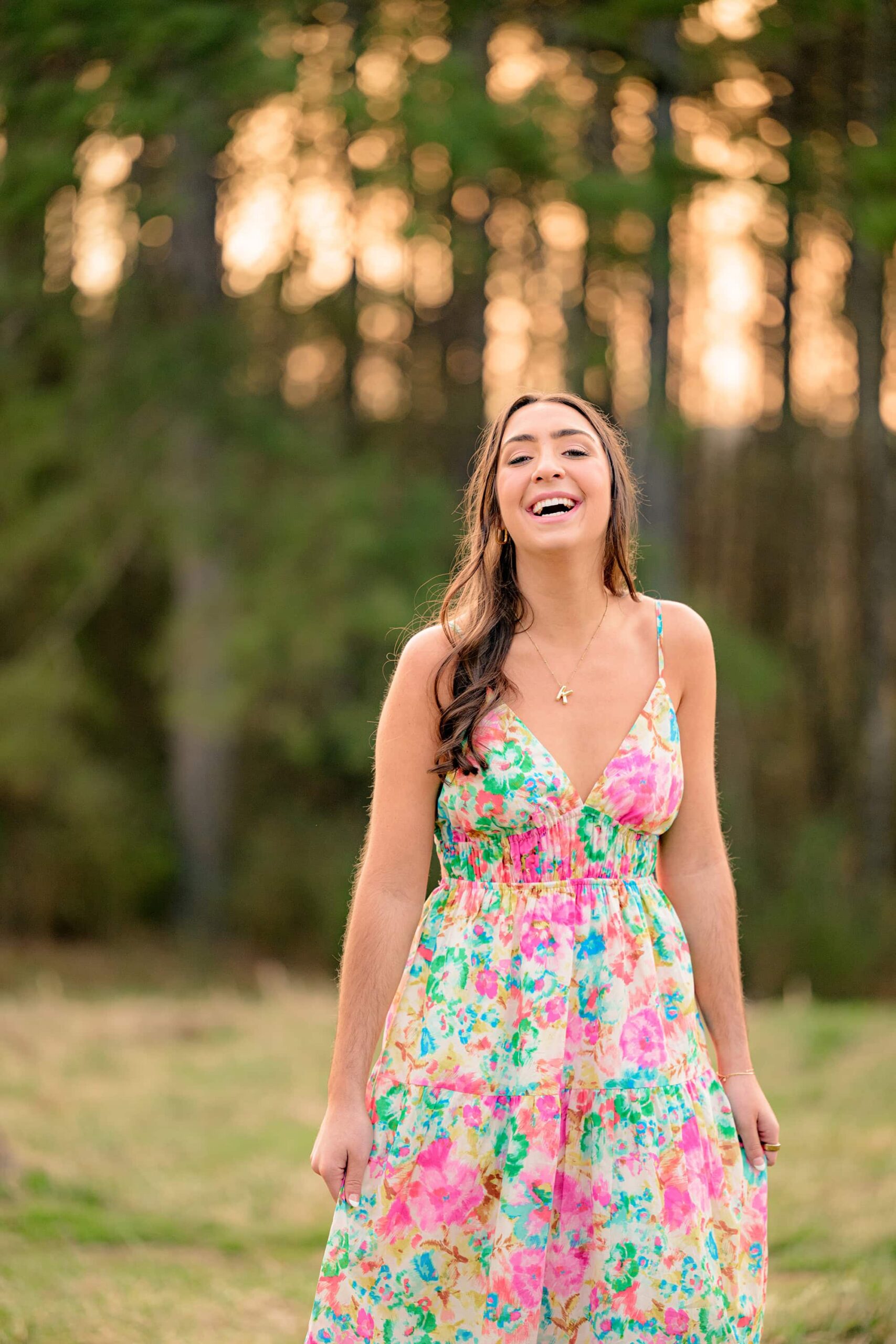 marvin ridge high school grad laughs as she stands in a field wearing a spring print dress