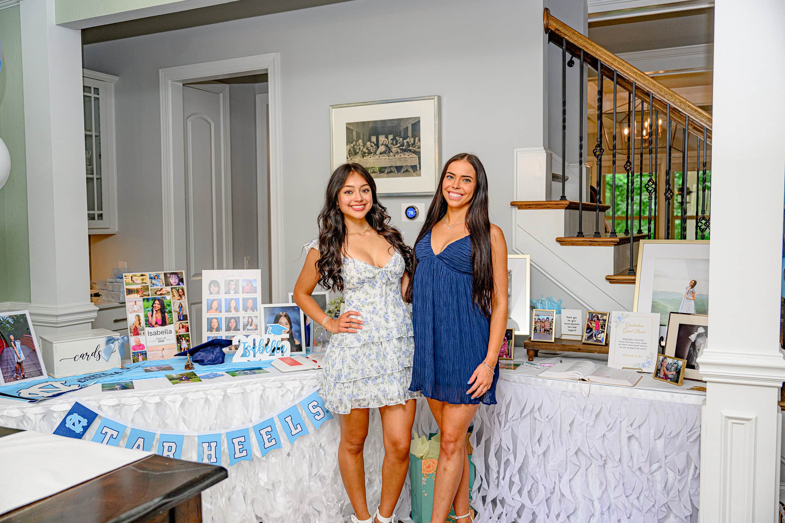 two best friends stand side by side in front of their celebration graduation tables during their senior grad party in charlotte nc