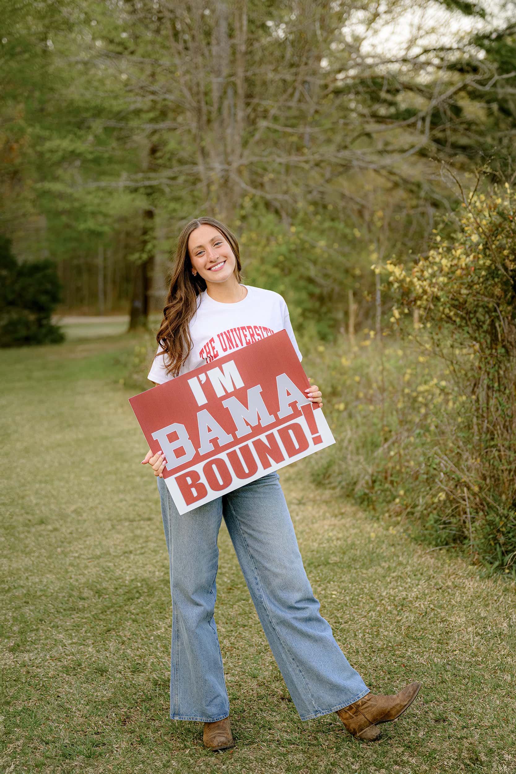 Charlotte Catholic Senior stands holding her Bama Bound sign as she celebrates graduating high school and her future college themed senior session