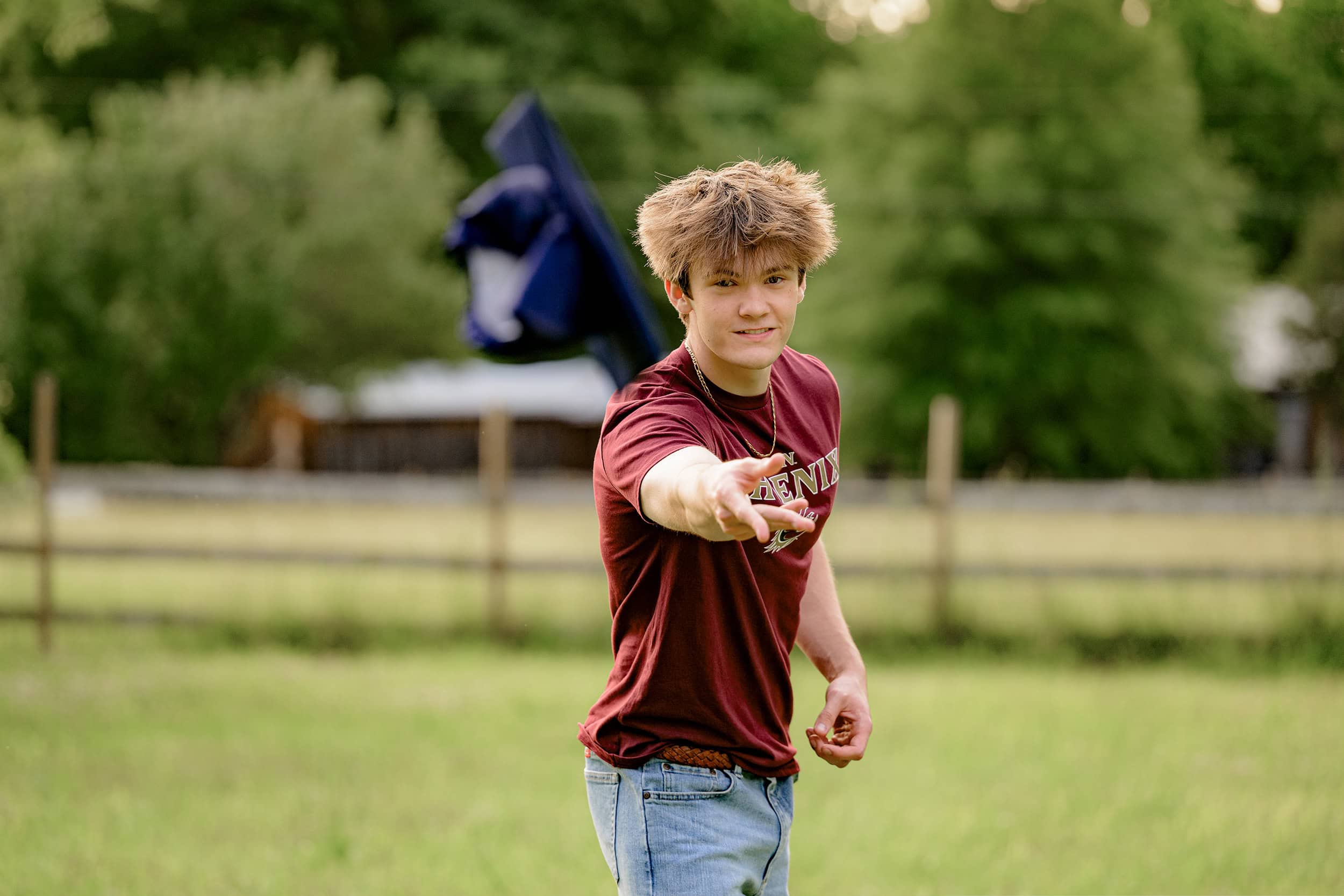 twin brother throws weddington high school cap during his bestie portrait session in a charlotte area field