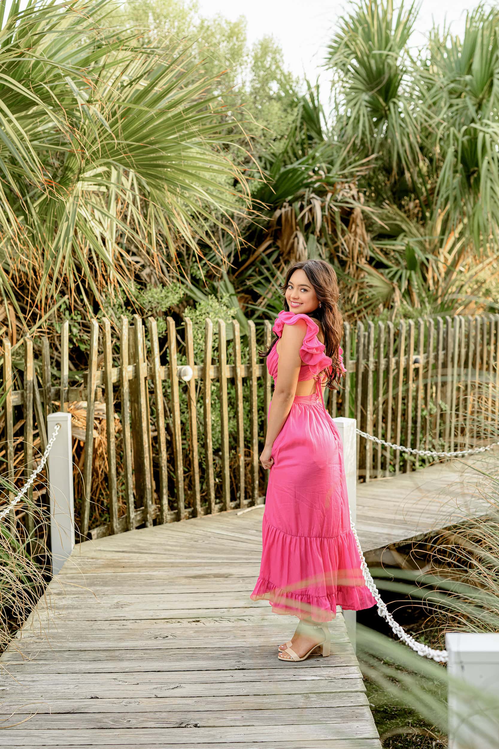 charleston boardwalk photo of charlotte graduate wearing a bright pink dress