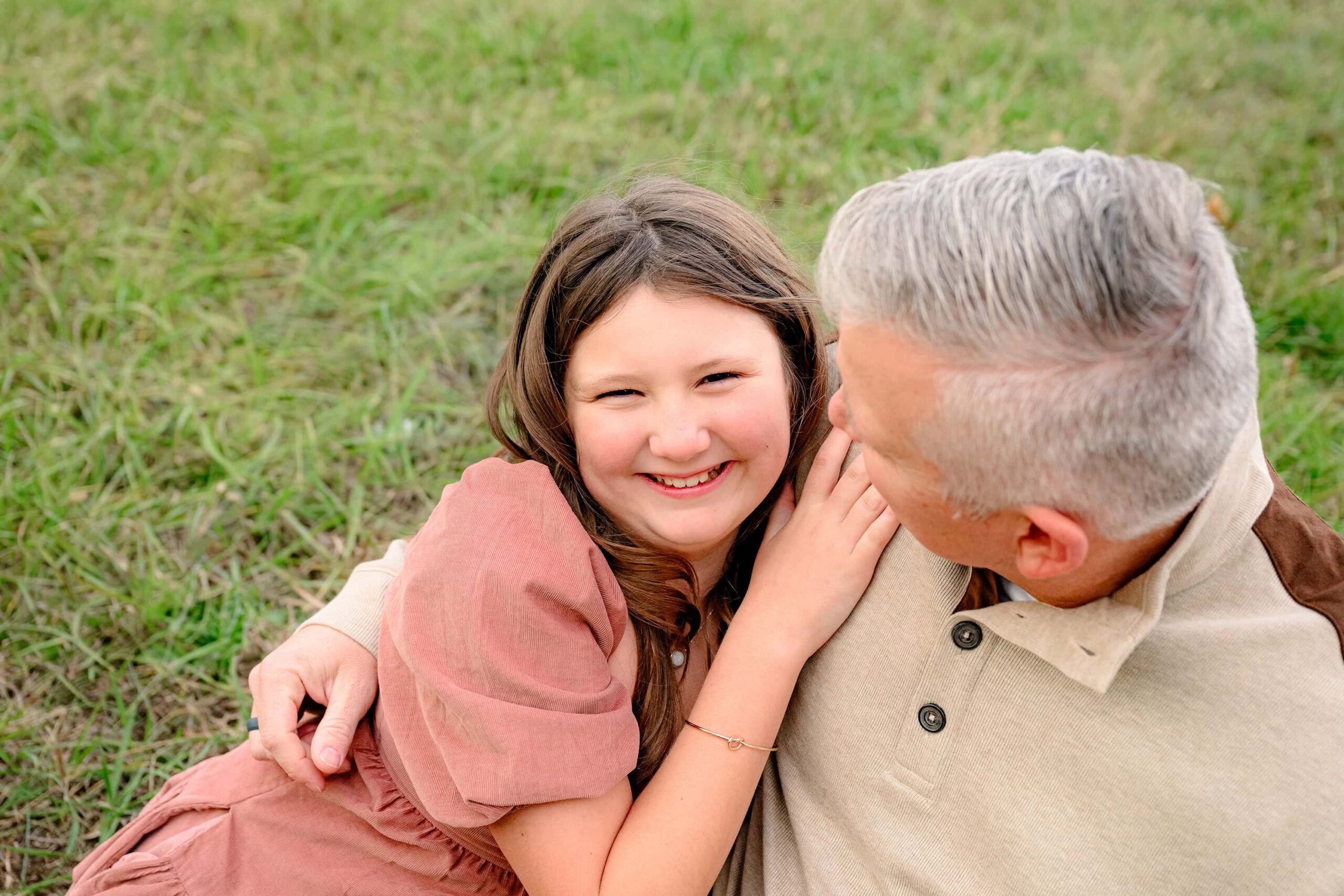 daughter laughing while leaning against her dad 