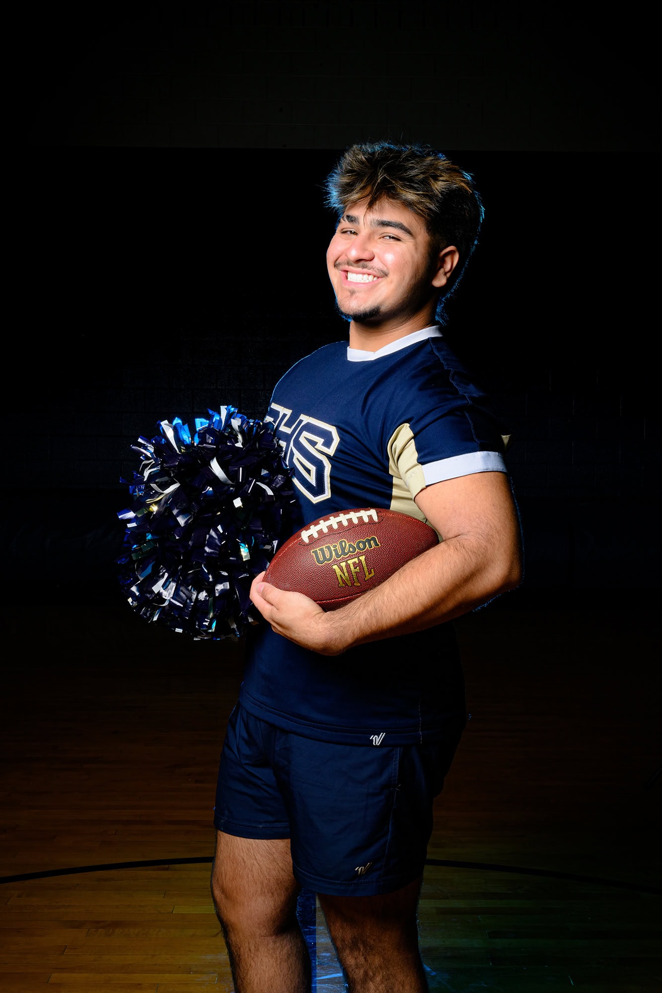 male high school cheerleader wearing his high school uniform for media day