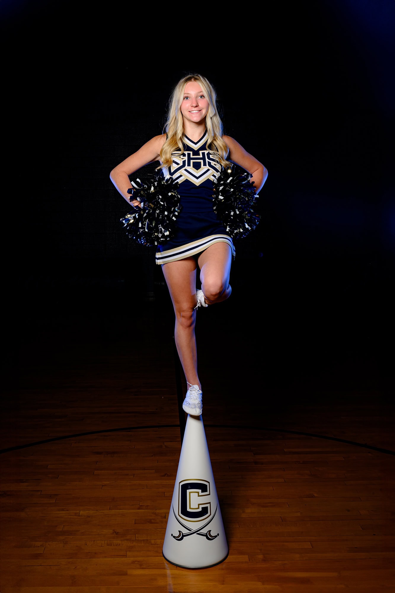 Cuthbertson high school cheerleader standing on a megaphone with her school symbol on media day