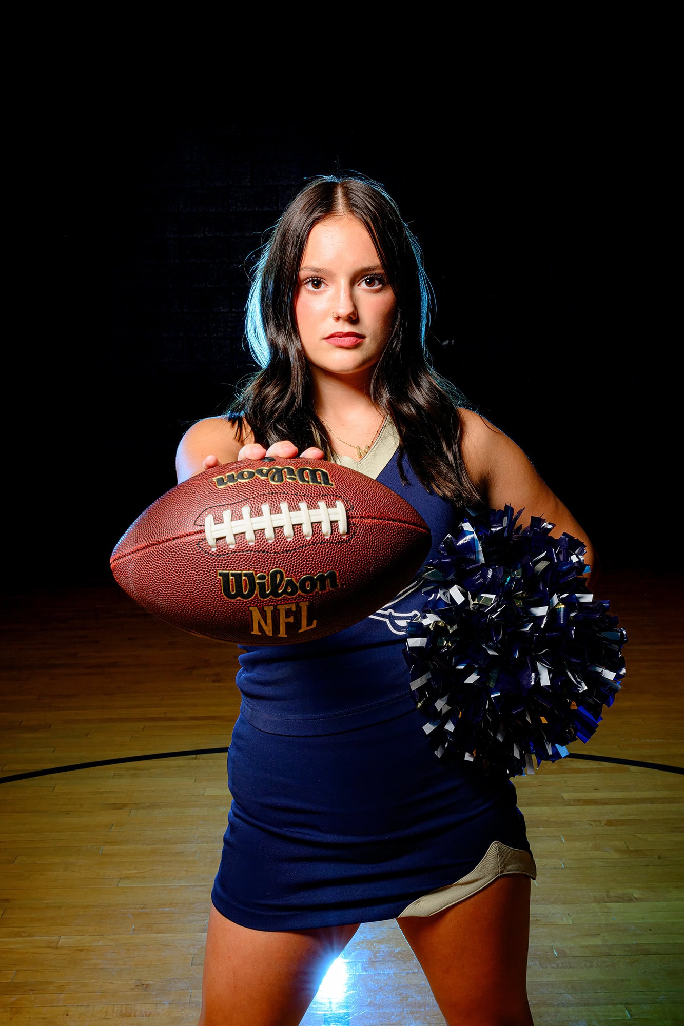 dark hair charlotte cheerleader holding football for media day promos