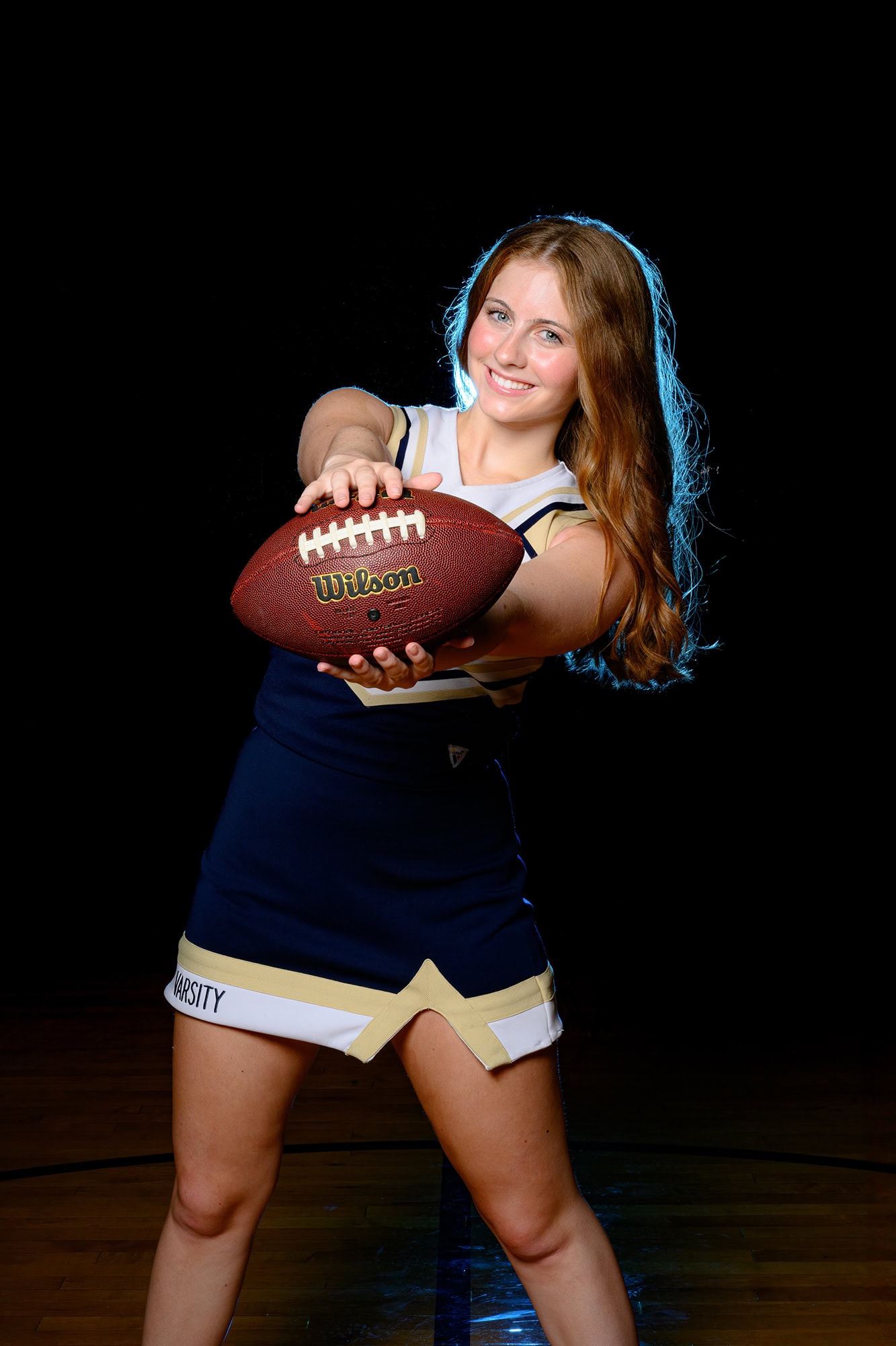 Media day image of Charlotte high school senior holding a football
