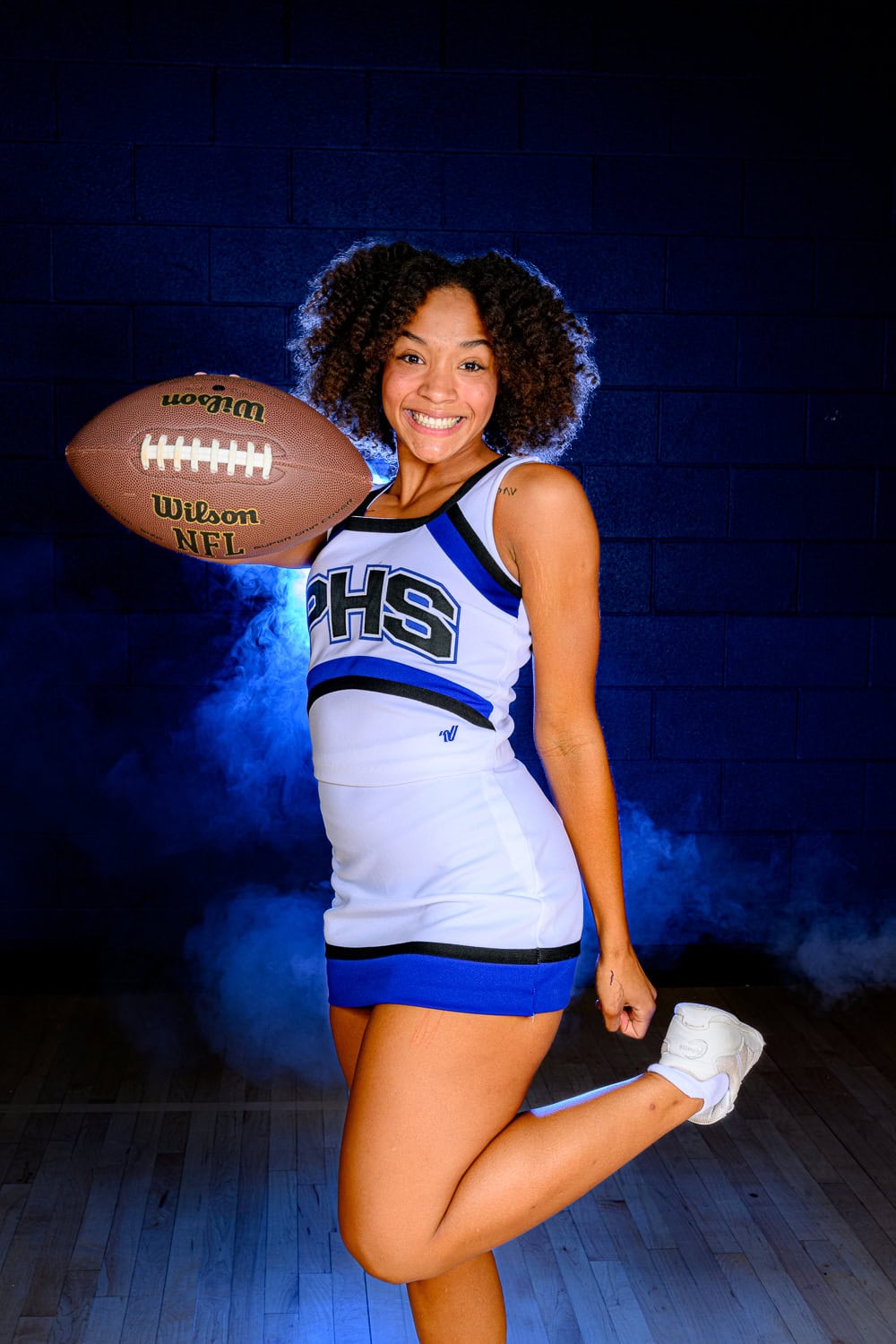 Parkwood High School senior holding a football for her photos