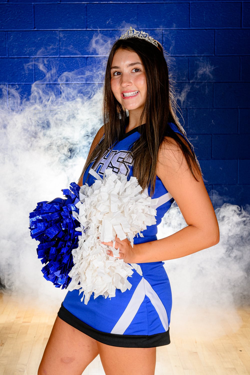 PHS cheerleader holding poms and wearing a crown