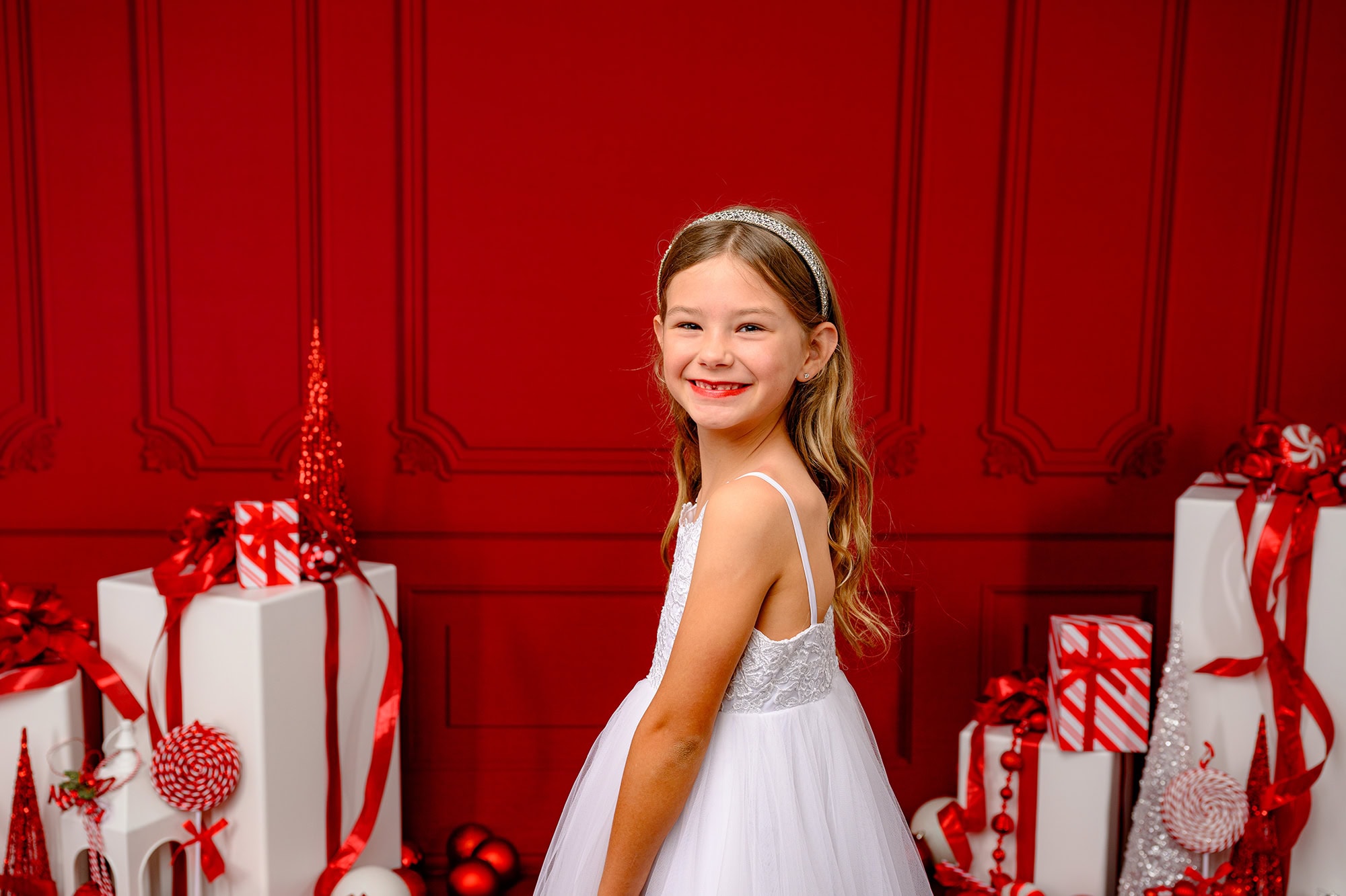 girl wearing a sparkle headband and white dress in a charlotte area studio holiday set up