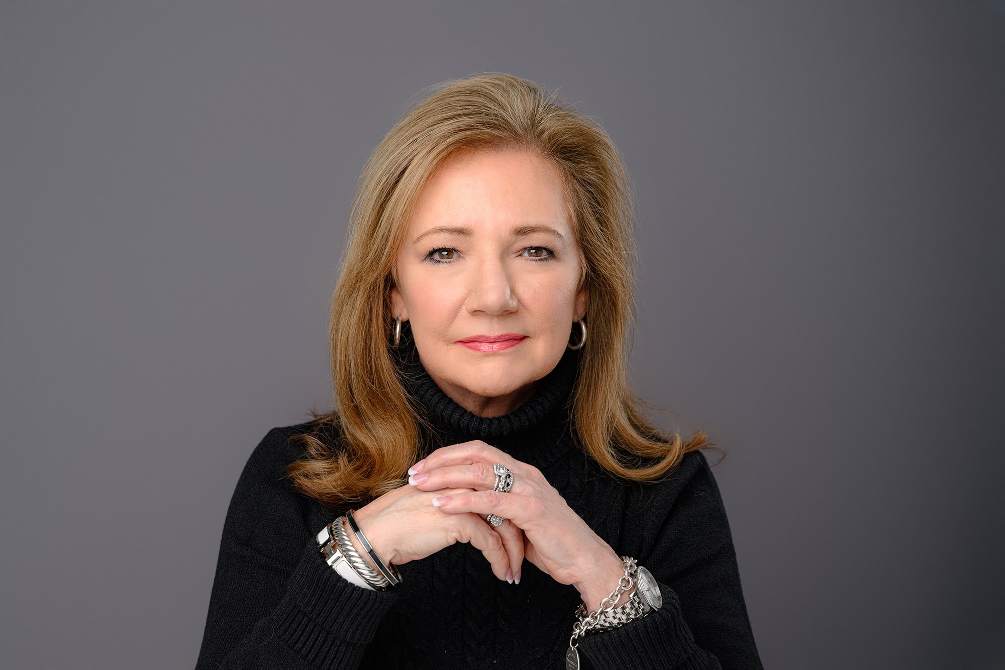 sales client styled her approachable headshot by wearing a black turtleneck sweater with her hair down