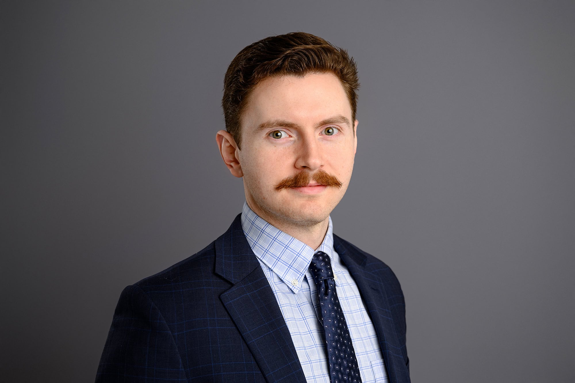 professionally styled charlotte headshot of man in blue suit and shirt with a mustache