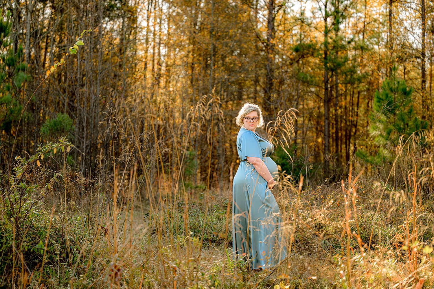 Charlotte maternity hospital employee Dr. Pekman stands in a field during her pregnancy photos