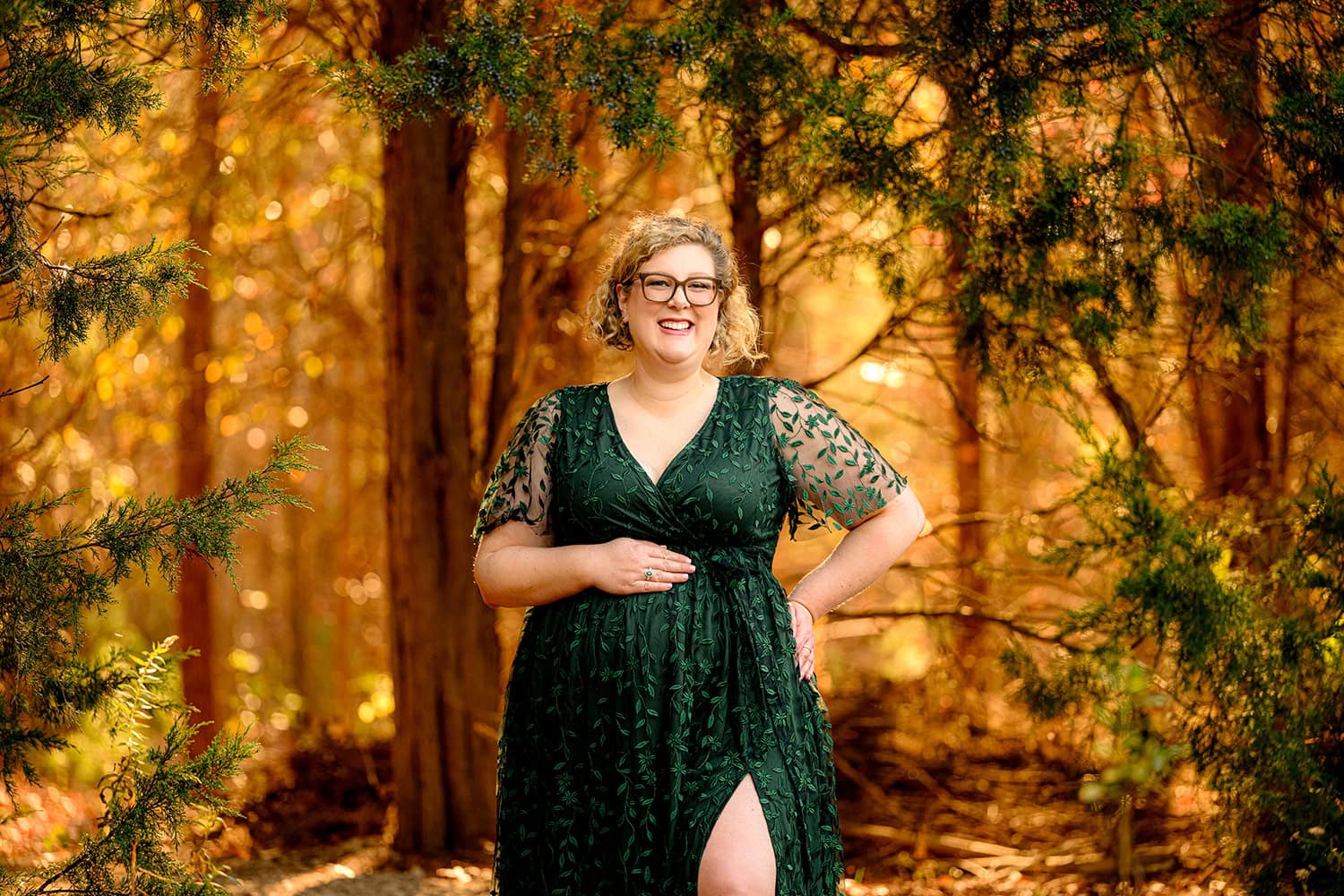 Charlotte mom to be stands in a wooded area for her maternity session before her baby delivery