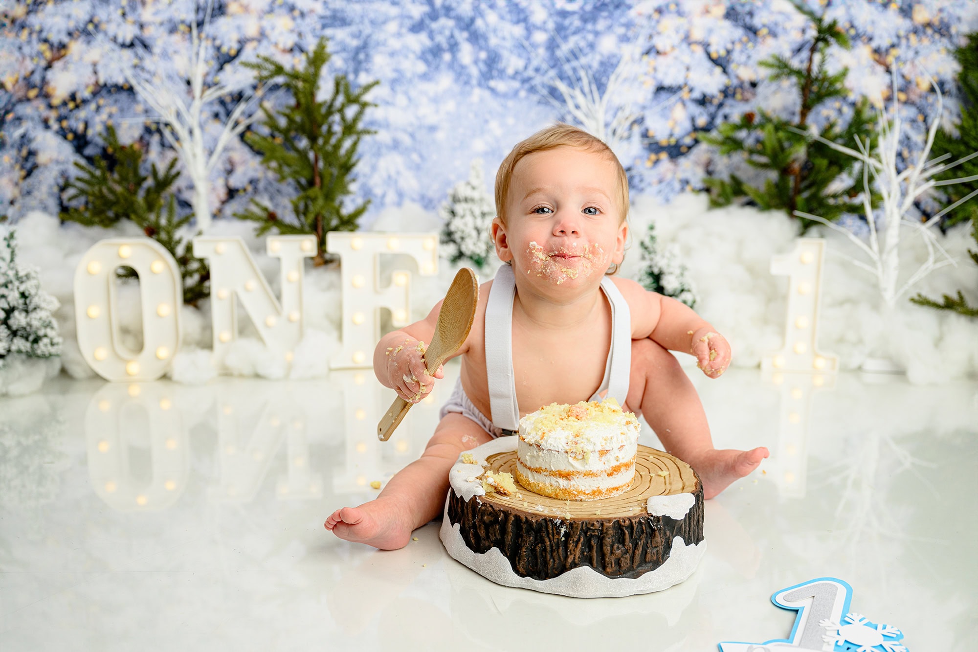 a giggly response by this charlotte area birthday boy as his smashes his birthday cake during his winter onederland photo session
