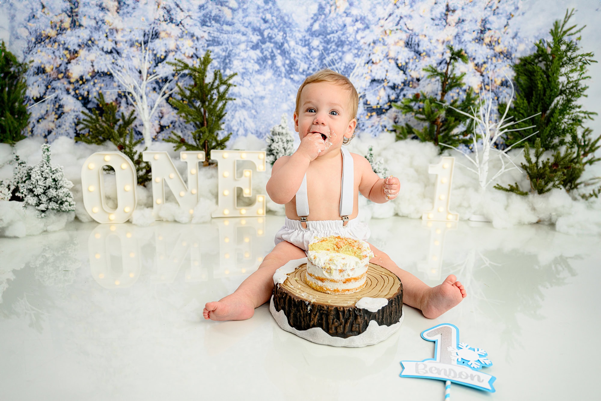 charlotte birthday boy celebrate his big milestone with a winter onederland cake smash by taking a bite of his cake