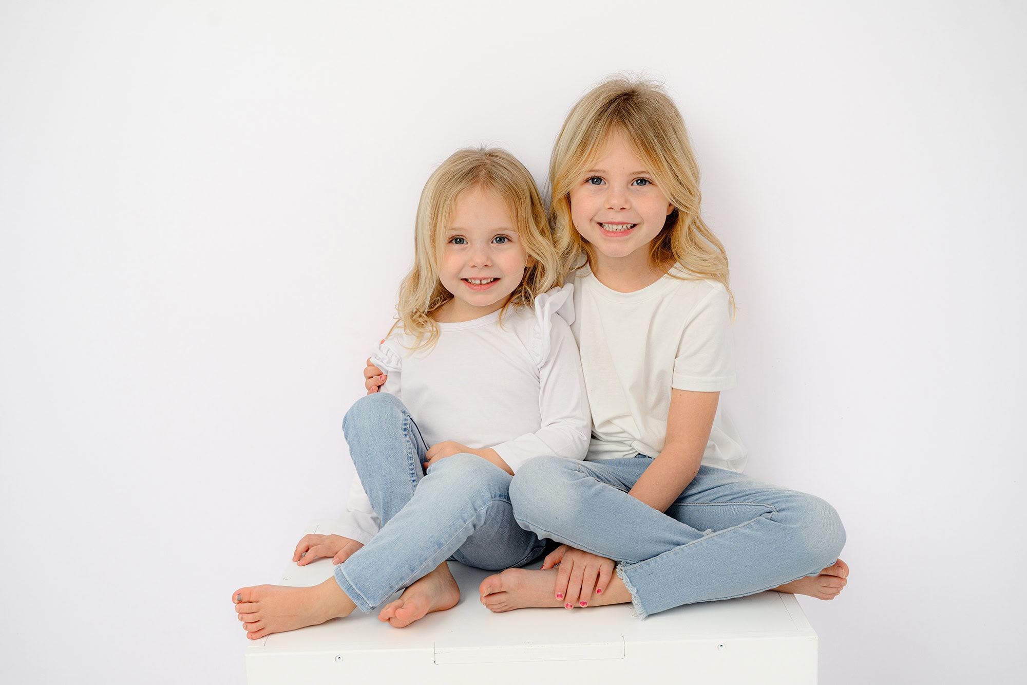 two little blonde girls in studio for classic photos during the winter months